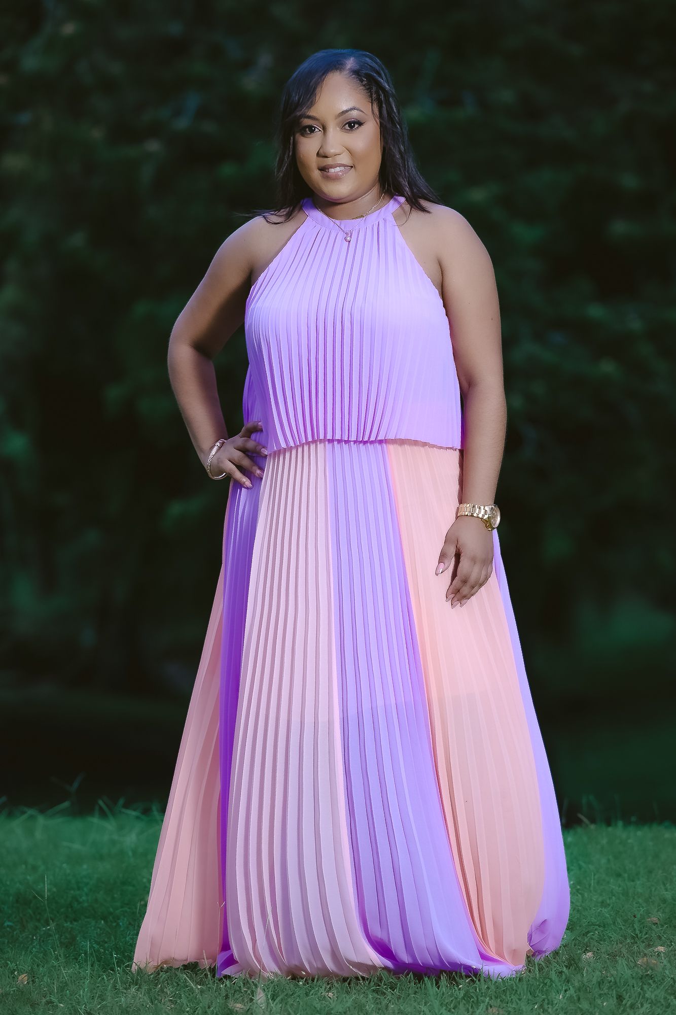 Woman wearing pleated color block dress in purple and pink tones.