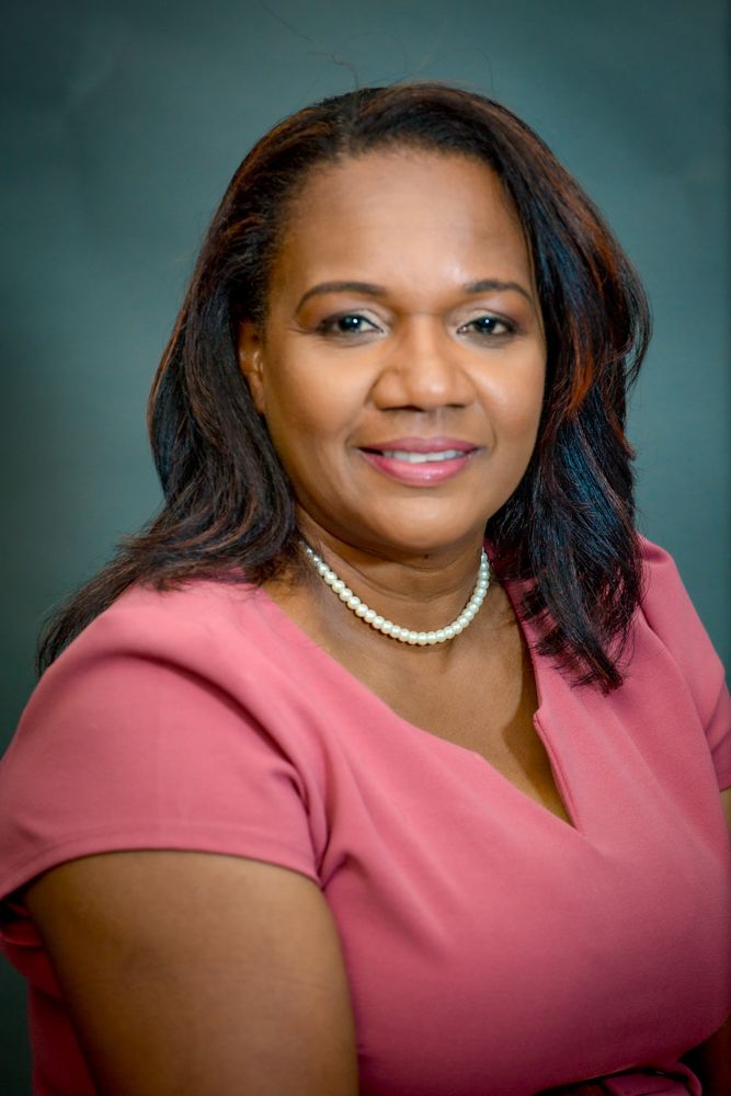 Professional portrait series showing someone in a pink dress and pearl necklace against a teal background.