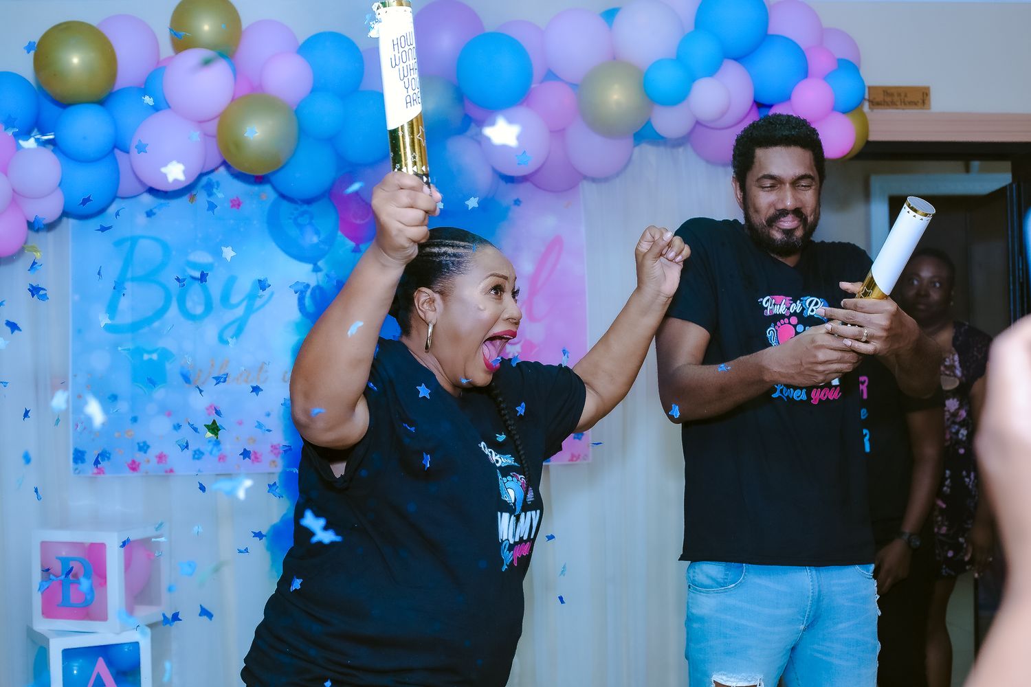 Celebration scene with blue and silver balloons as people hold sparklers at party.