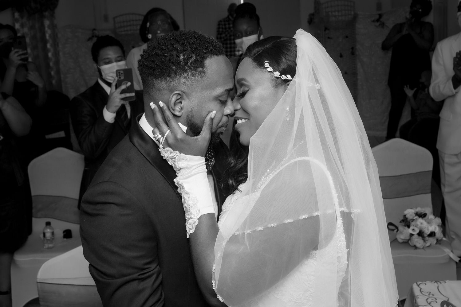 A tender moment between newlyweds during their wedding ceremony captured in black and white.