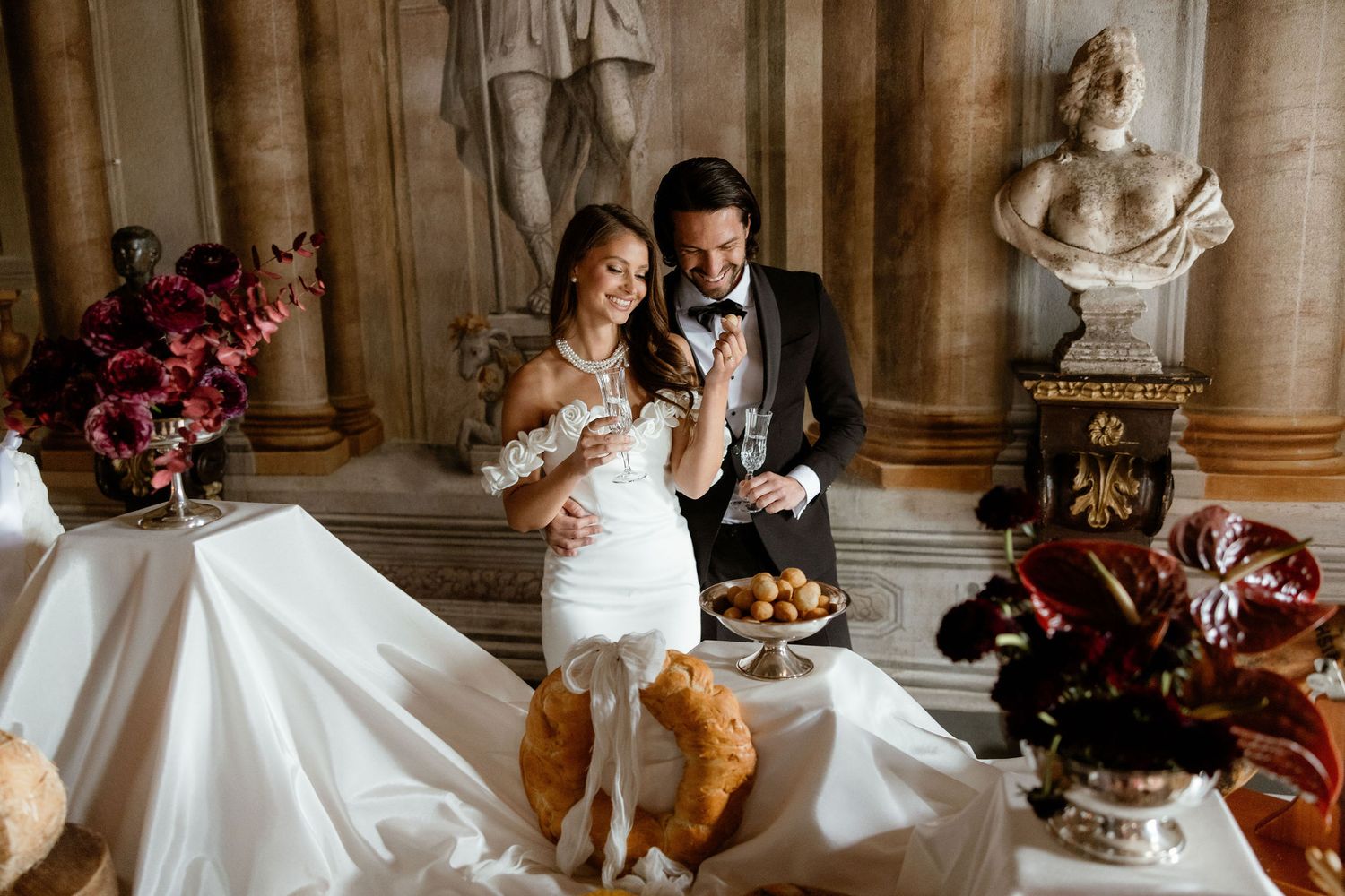 Couple shares a sweet moment during their wedding while wearing formal attire and cozy slippers in an elegant room.
