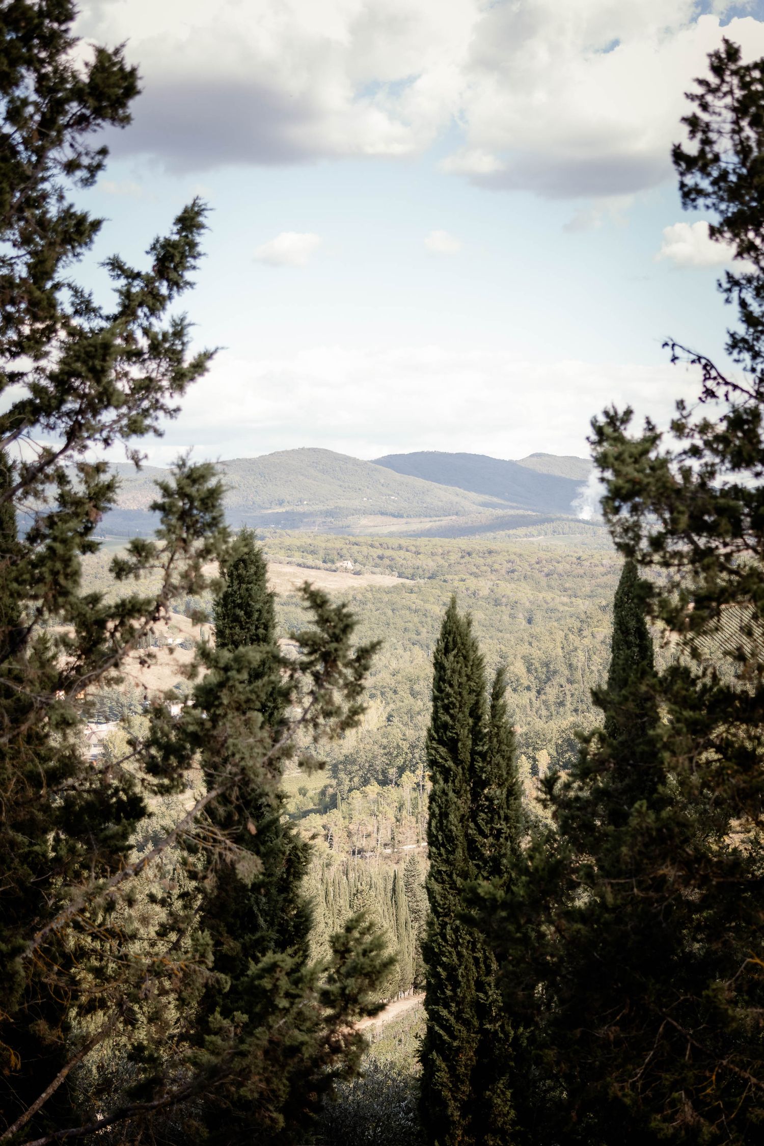 Scenic mountain landscape view through cypress trees in Tuscany.
