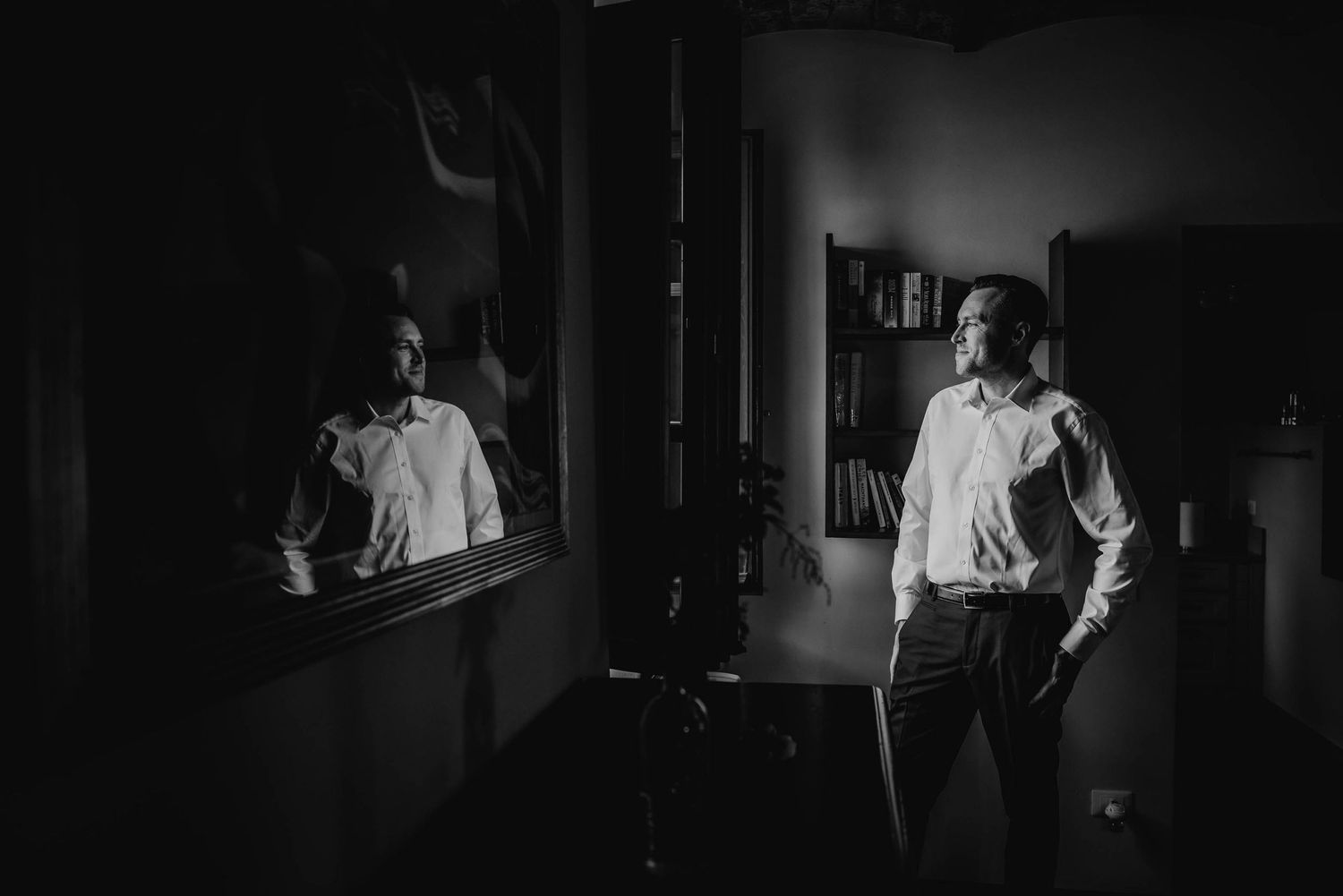 Black and white image of a formal reflection in a dimly lit room.