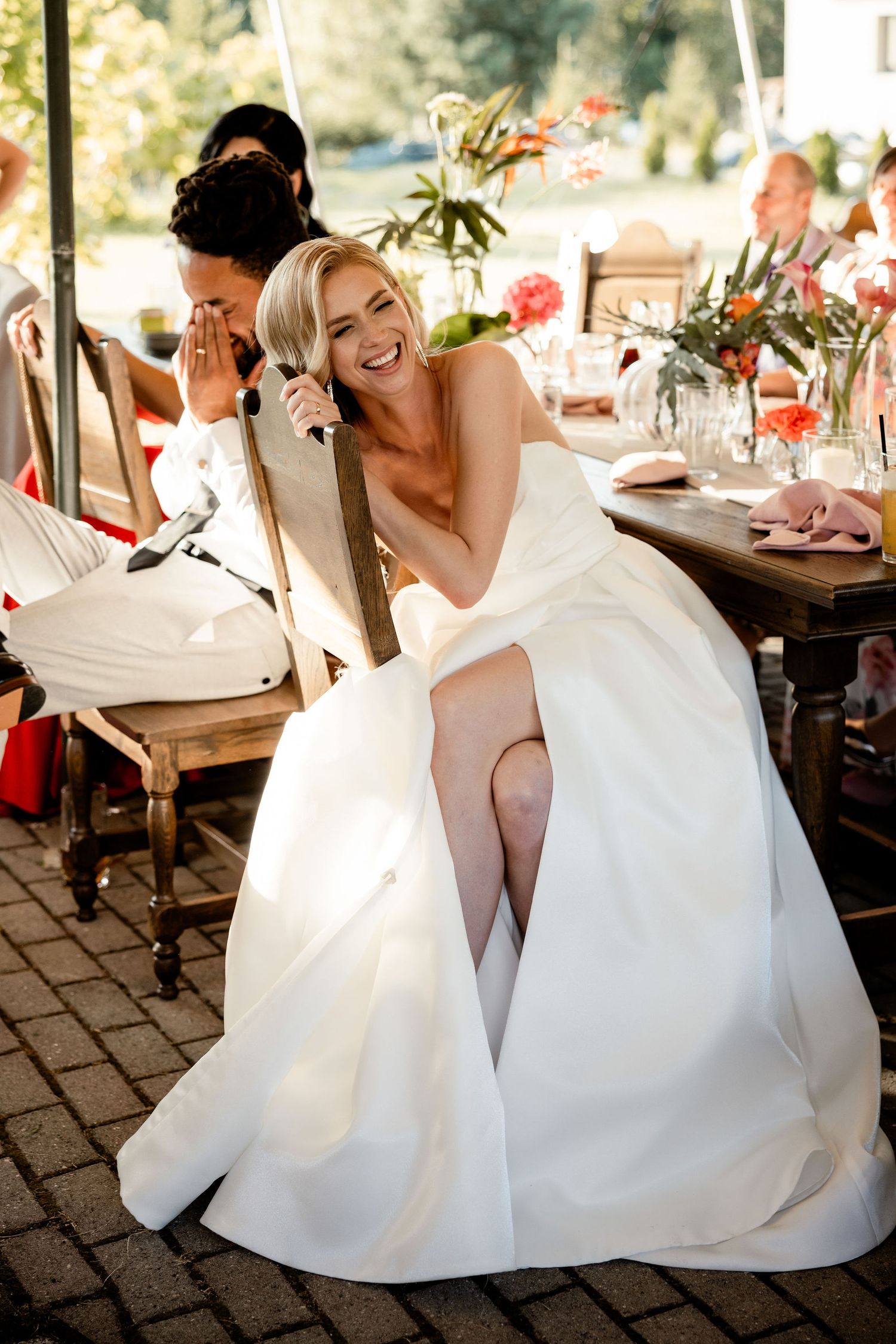 A candid moment of joy and laughter during an outdoor wedding reception.