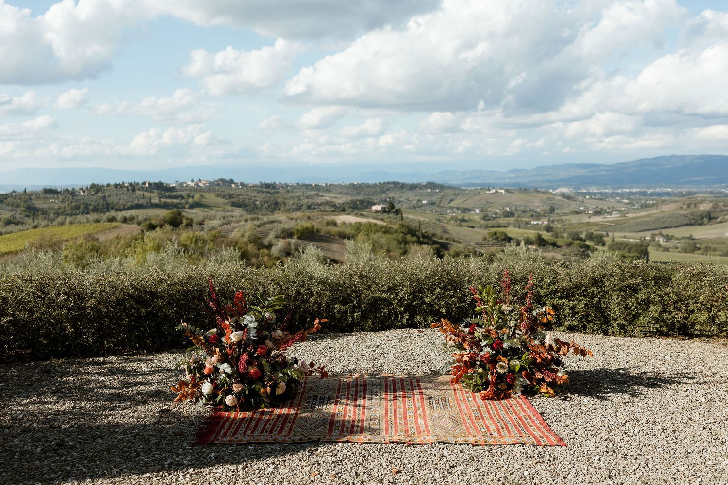A scenic mountain landscape with rustic wedding ceremony setup featuring floral arrangements and seating.