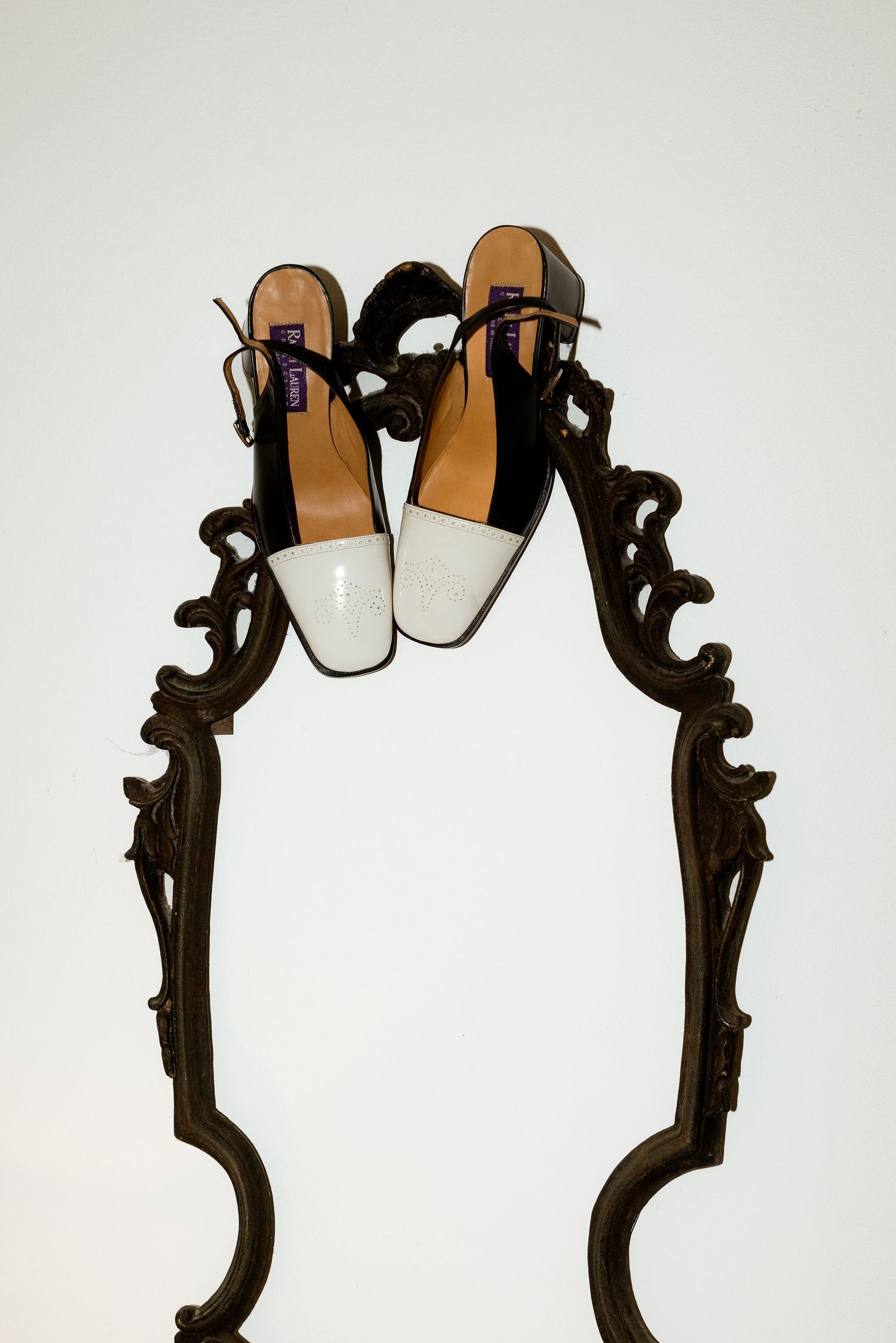 Ornate black metal mirror frame with decorative scrollwork and floral motifs against a white background.
