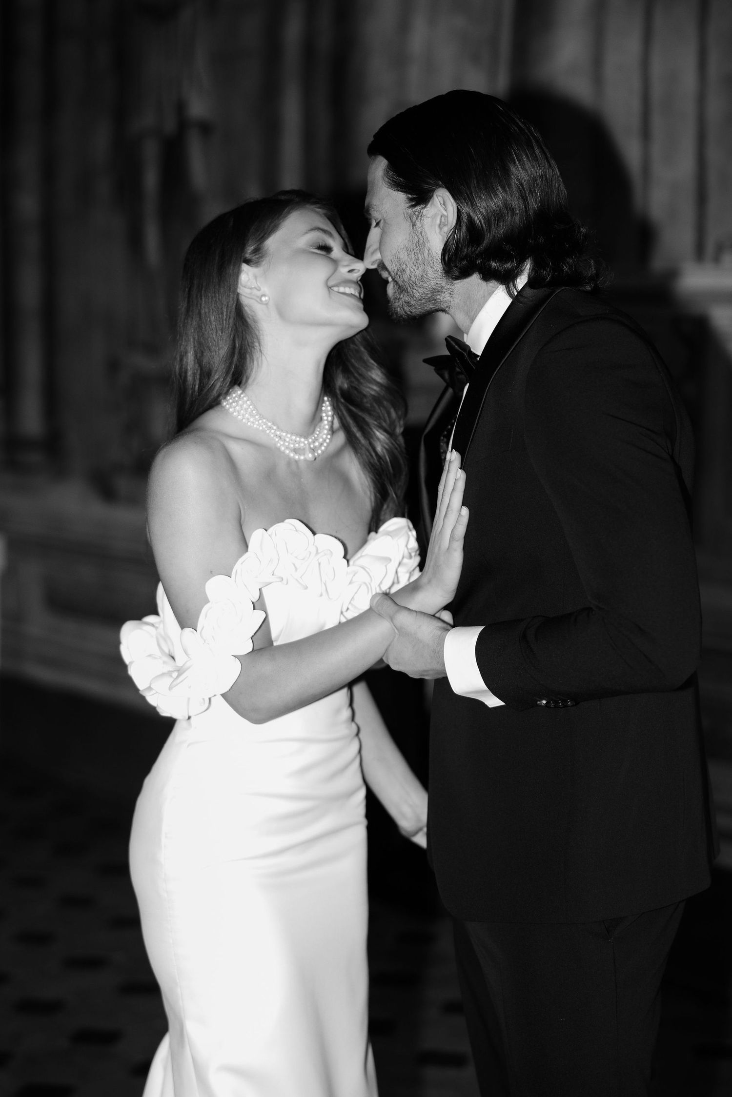 Black and white photo series captures intimate wedding kiss moments between bride in white dress and groom in dark suit.