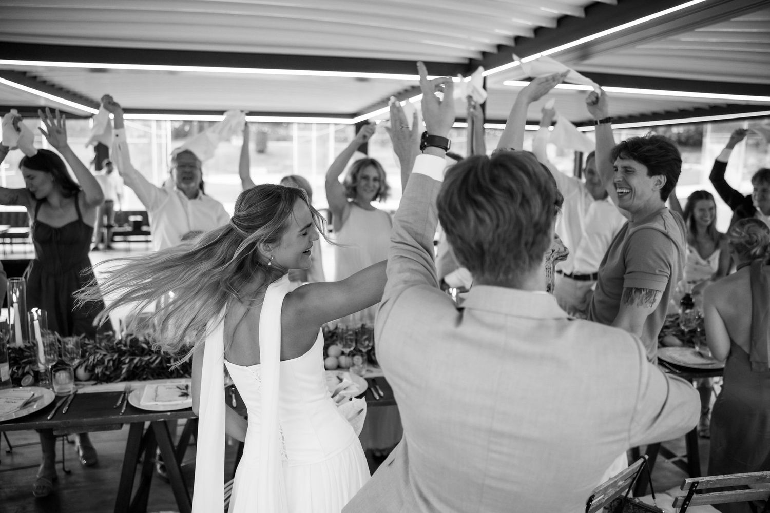 A lively dance party at a wedding reception with guests enjoying themselves on the dance floor.