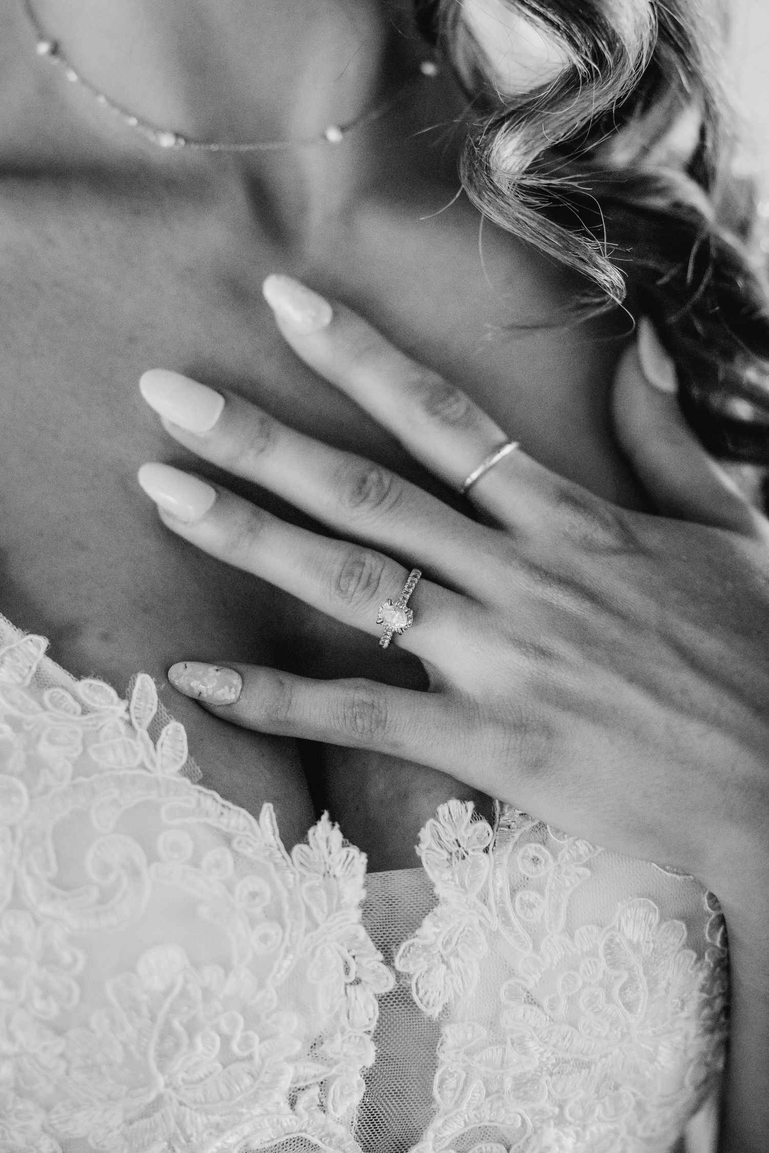 Close-up detail of lace wedding dress and delicate jewelry.
