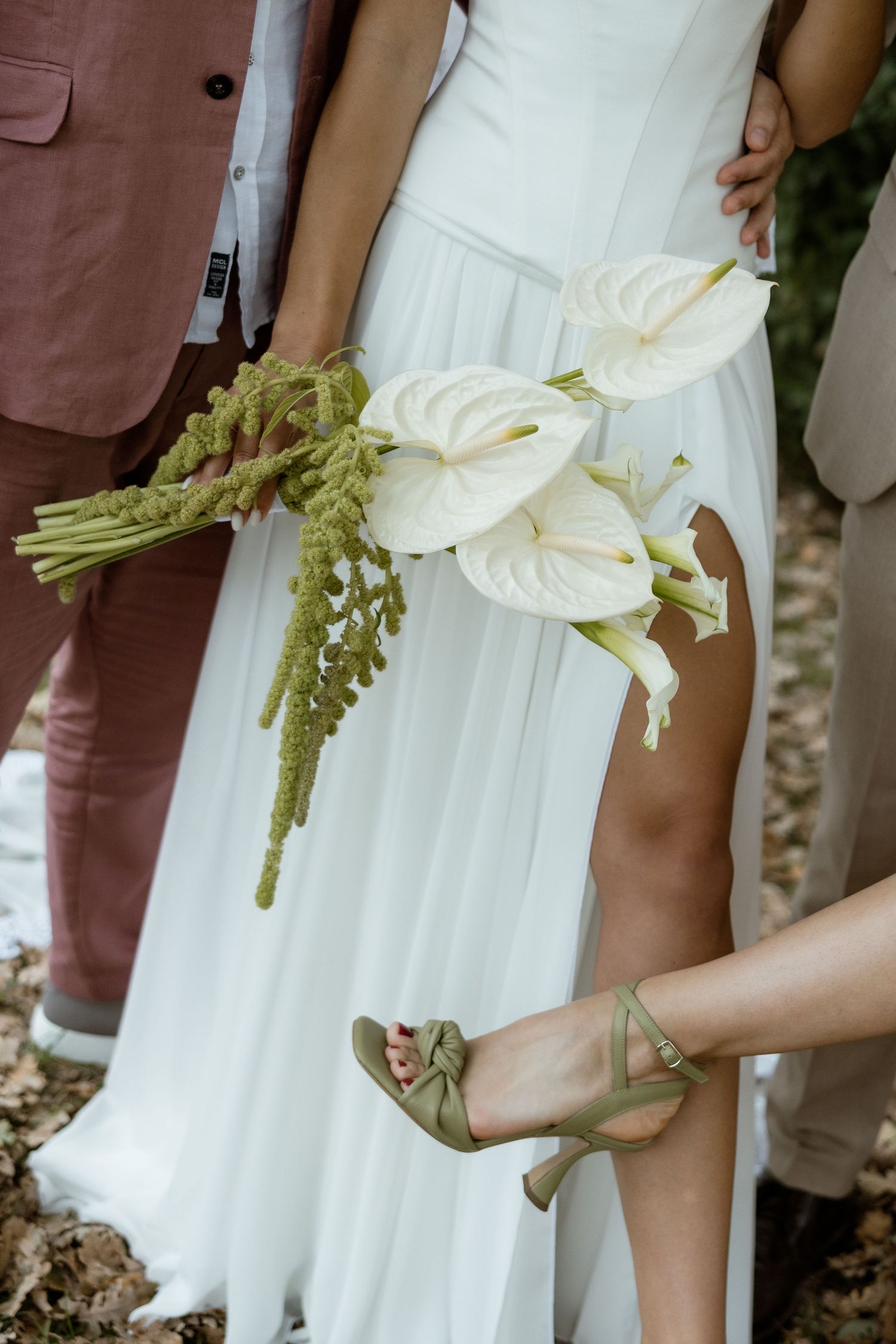 Close-up shots of bridesmaids in white dresses holding green and white floral bouquets at a wedding ceremony.