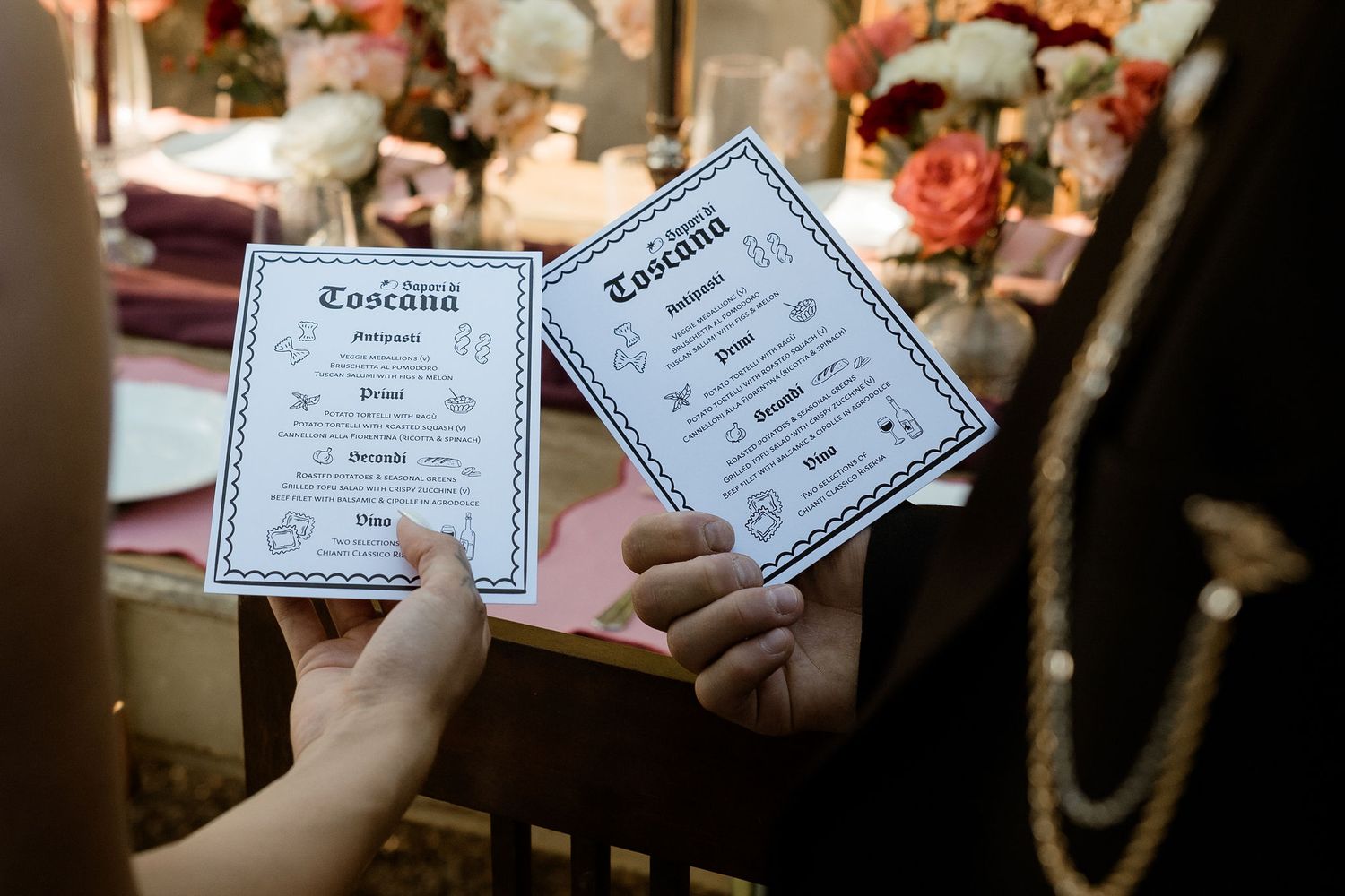 Hands hold up marriage certificates against a blurred background at a wedding ceremony.