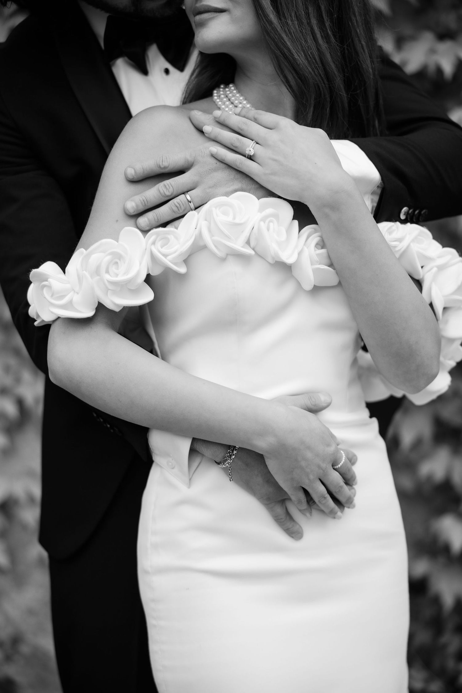 Black and white photo series showing close-up details of a pregnant woman's belly with hands resting gently on it.