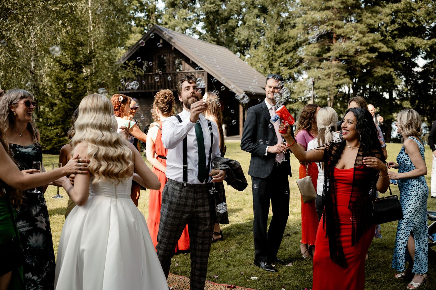 Wedding celebration outdoors with guests dancing and mingling on a sunny afternoon.