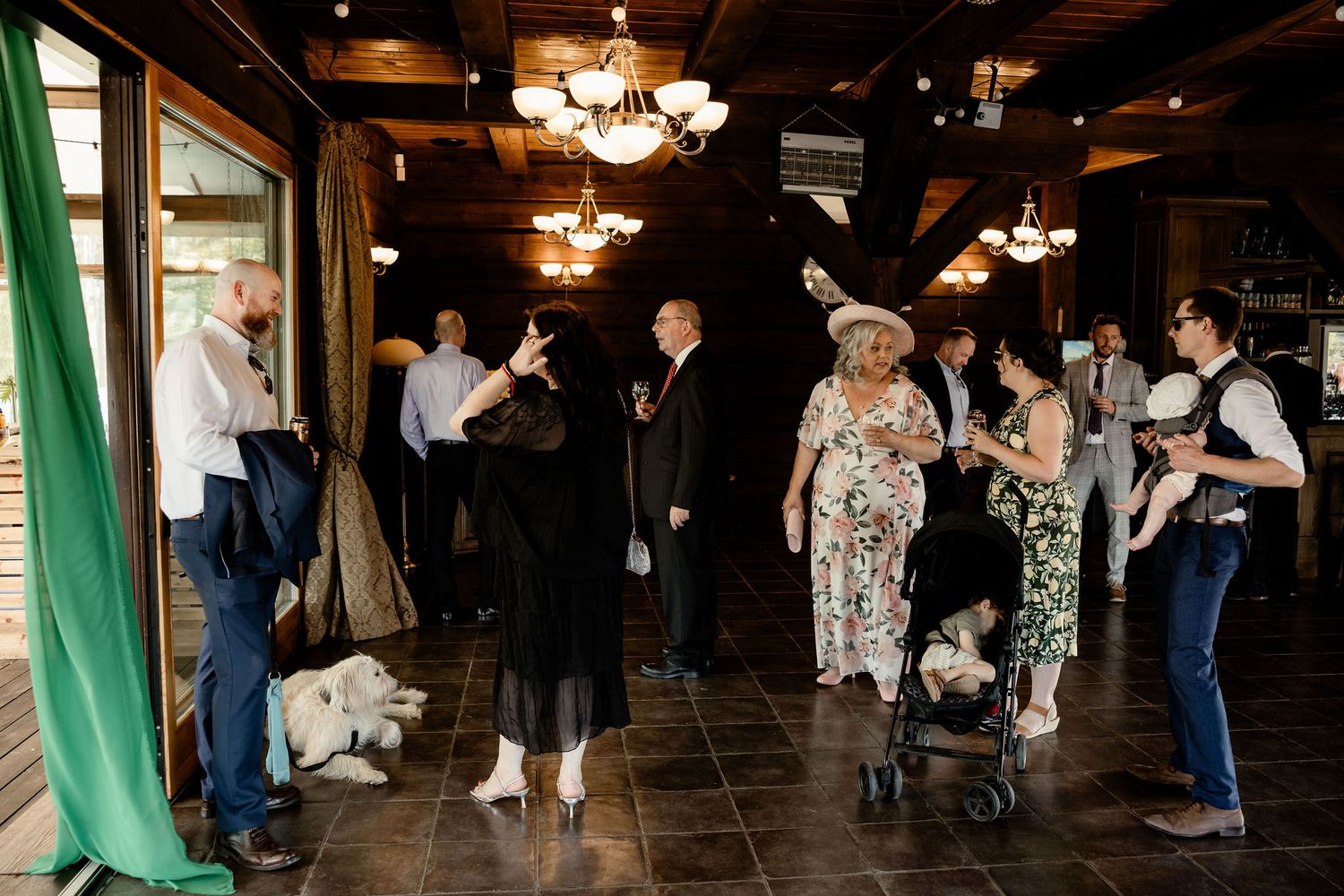 Wedding reception scene in a dimly lit venue with guests mingling.