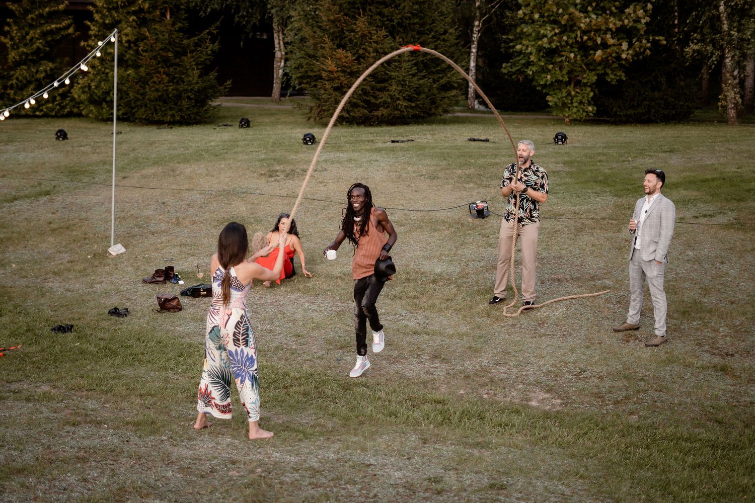 Group of people playing outdoor volleyball at a wedding celebration during a casual summer gathering.