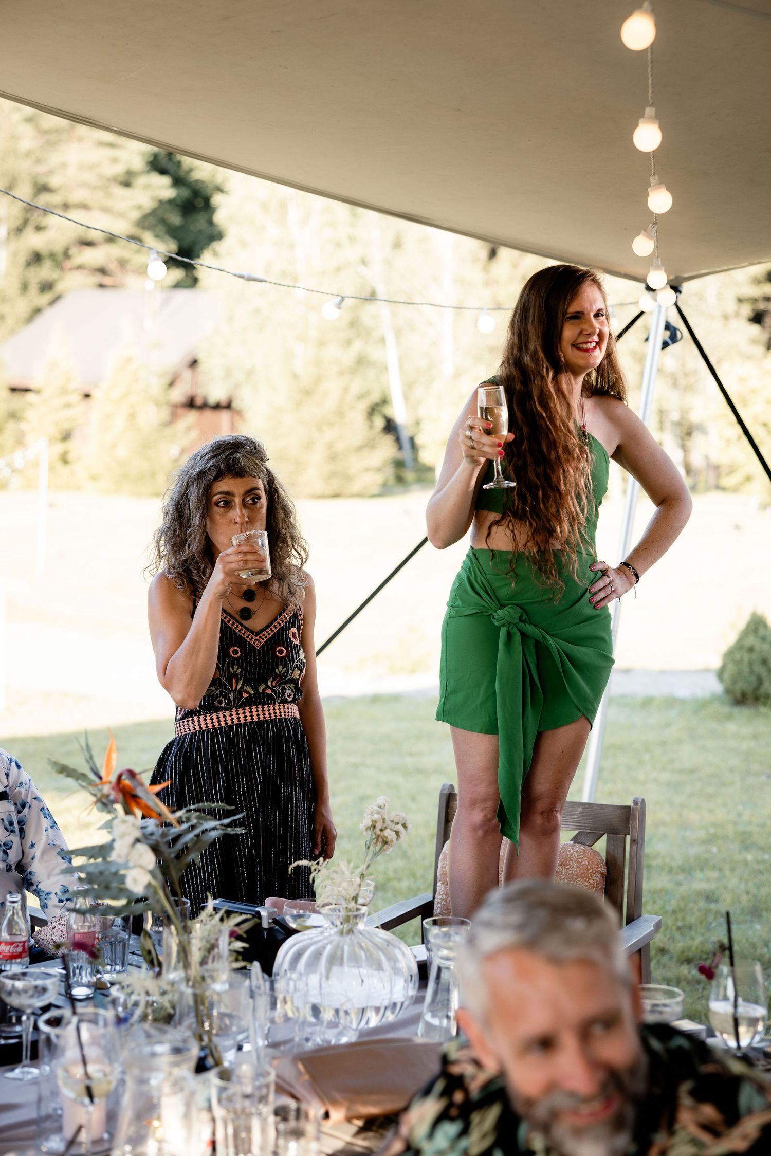 Wedding guests enjoying drinks and conversation at an elegantly decorated outdoor table.