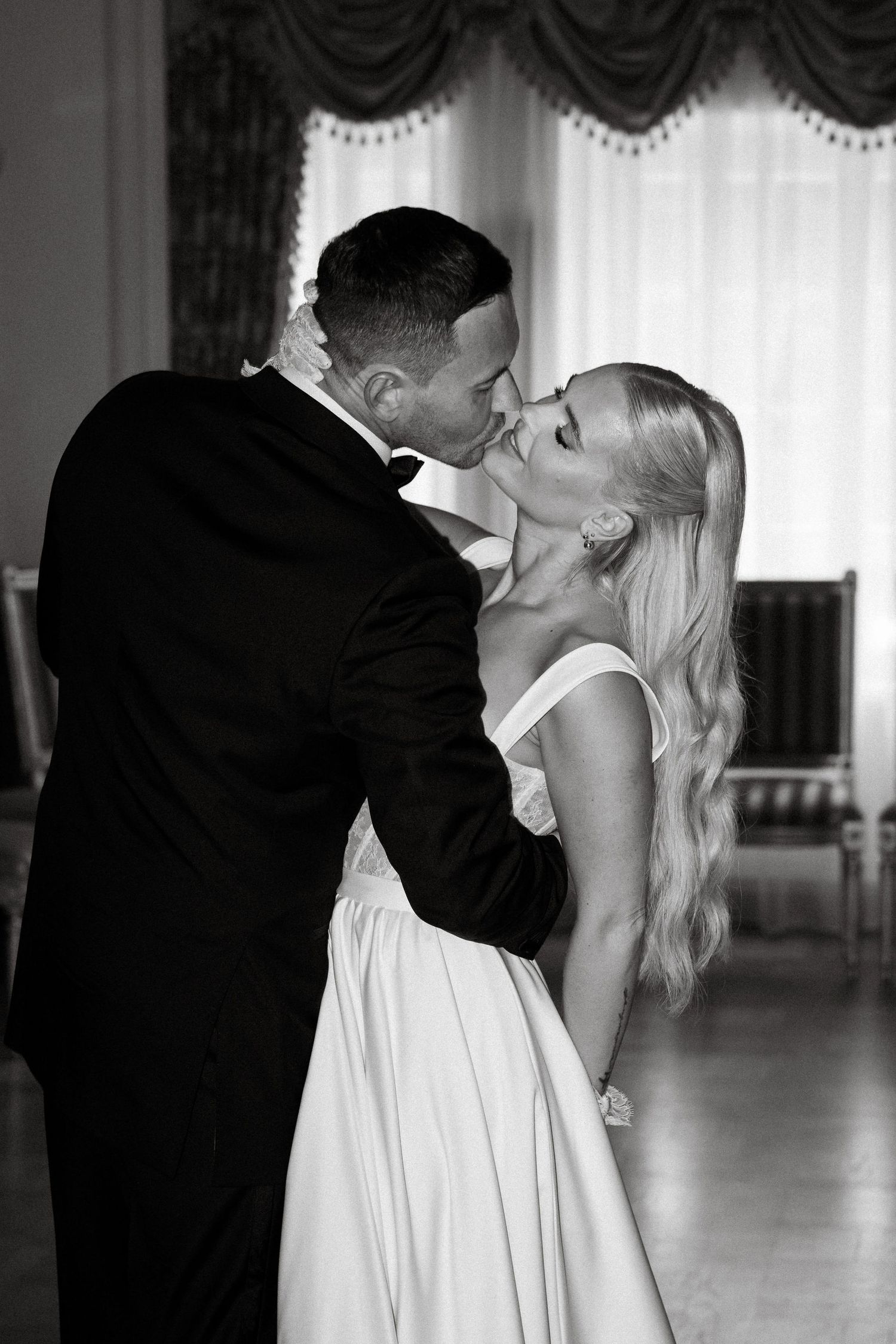 A romantic black and white portrait shows a couple in an intimate dancing pose.