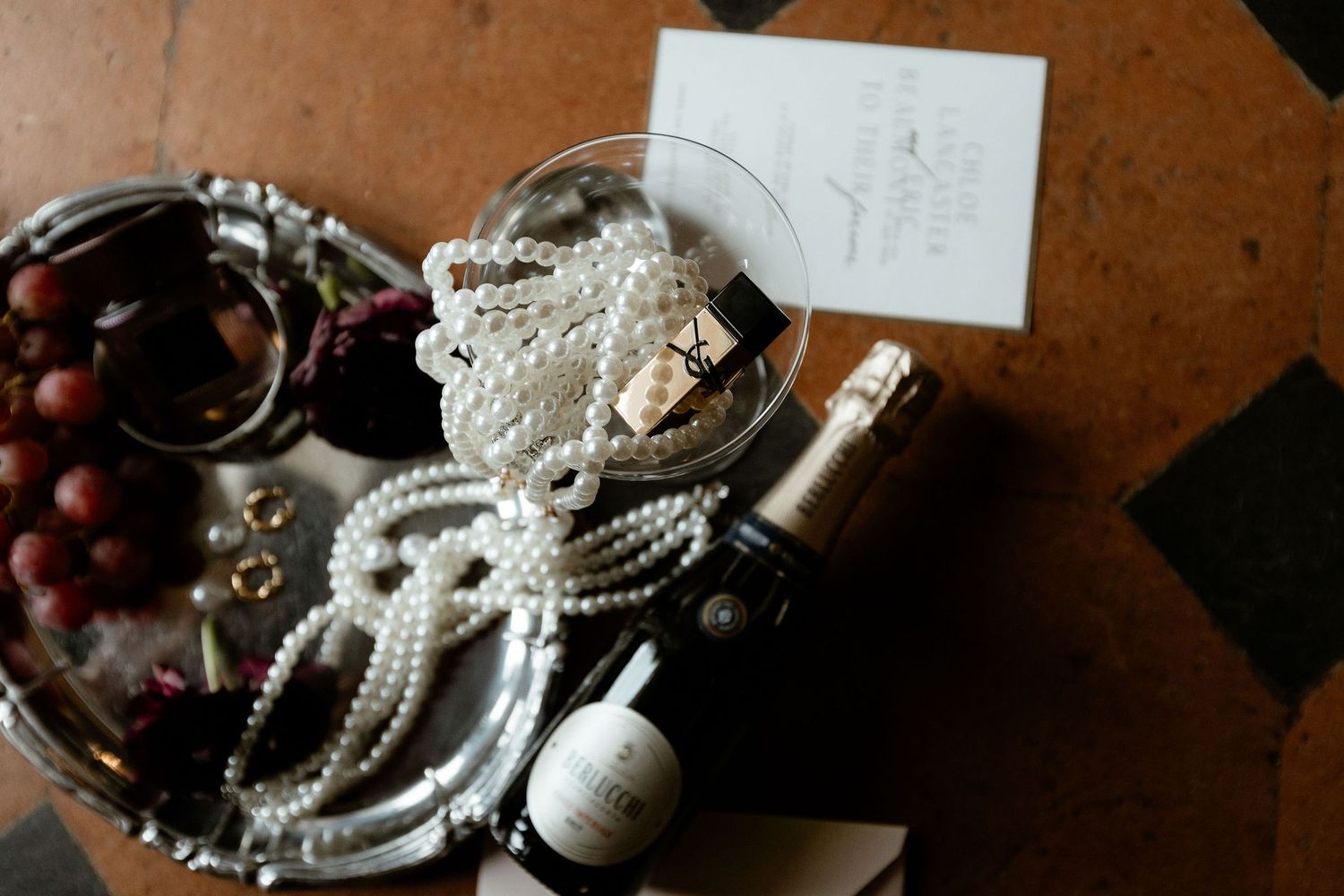 A collection of delicate pearl necklaces and jewelry pieces arranged in an ornate bowl on a wooden surface.