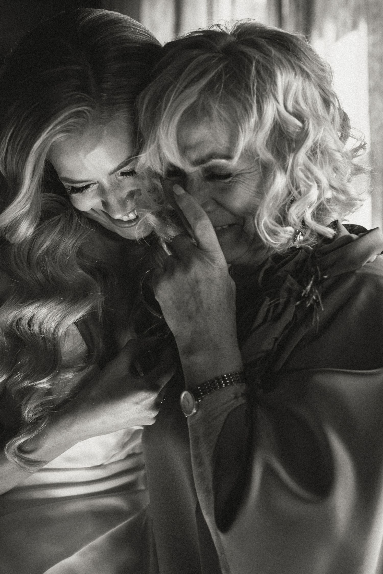 Black and white photo showing two people sharing a candid laughing moment.