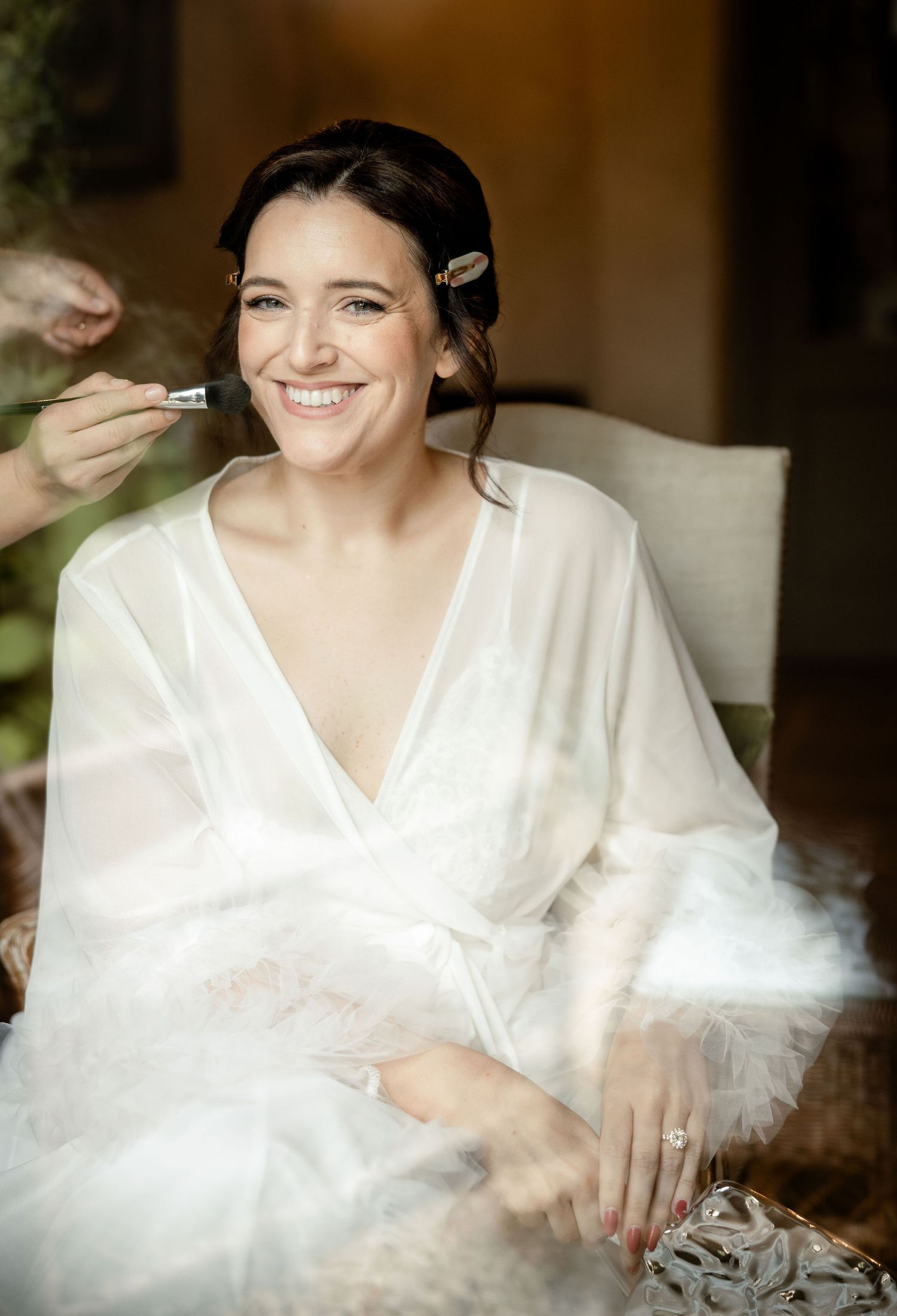 A series of five photographs showing a person in a white robe smiling while sitting in an elegant indoor setting.