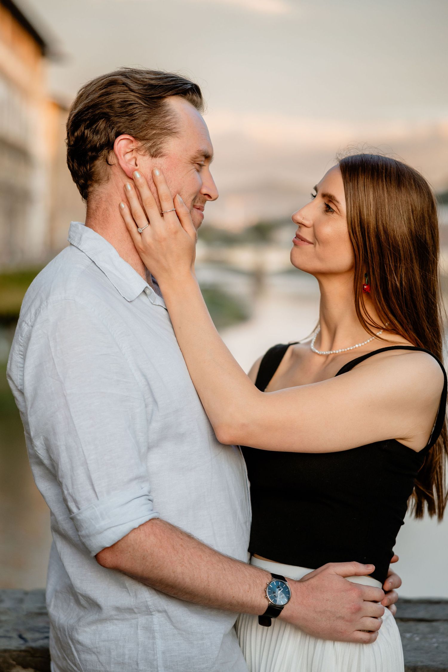 A romantic moment between a couple in casual attire sharing an intimate embrace during sunset.