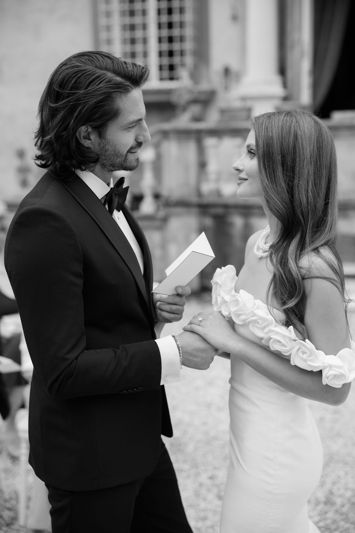 A heartfelt black and white wedding moment between a couple as they share vows outdoors.