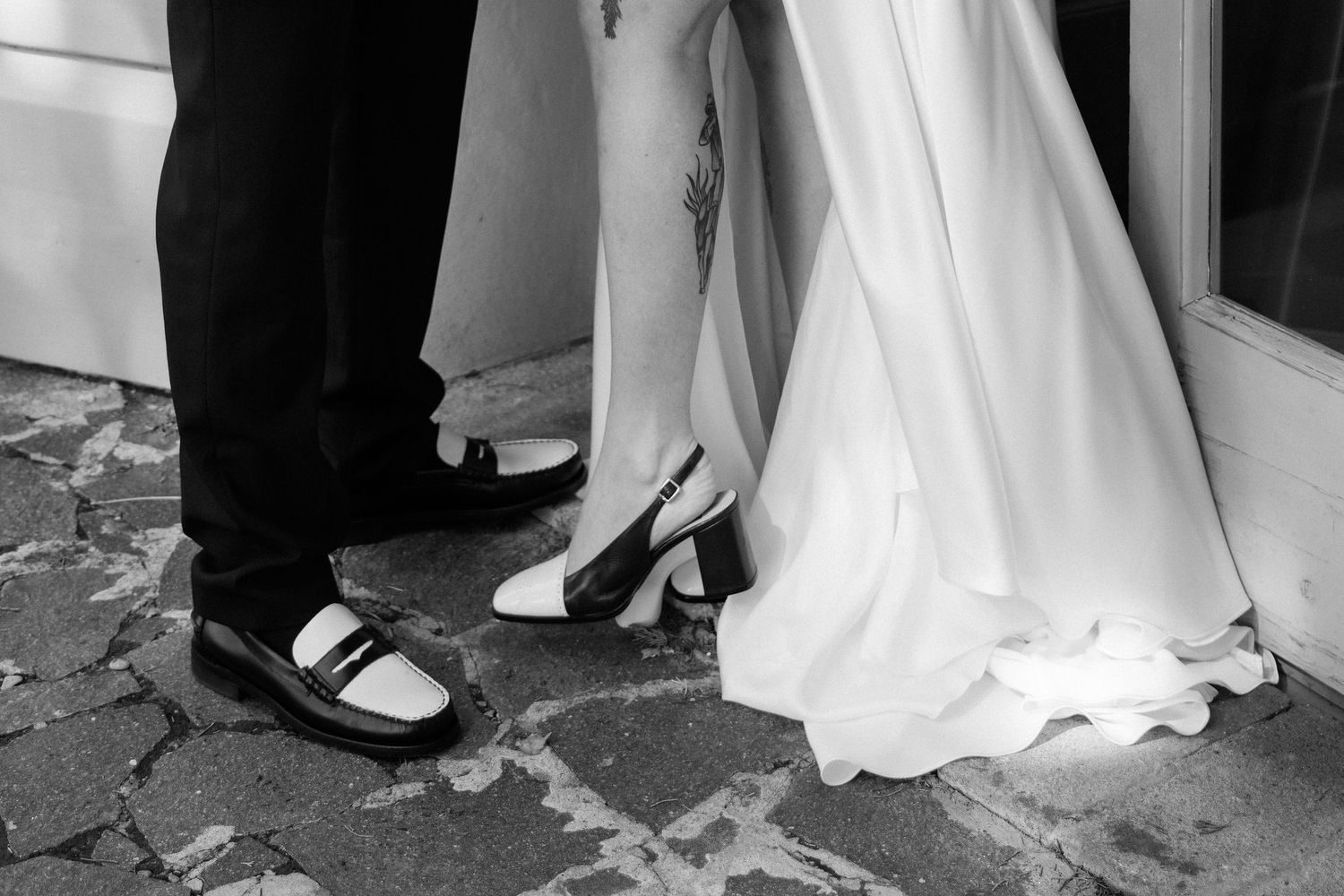 A series of black and white wedding photos showing feet and the bottom of a wedding dress on stone steps.