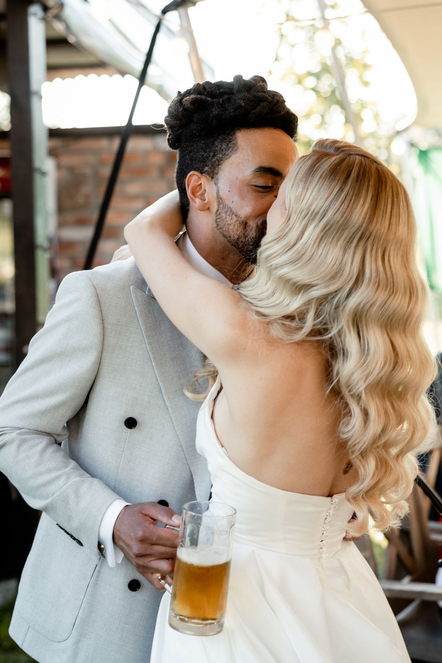 A romantic moment between newlyweds sharing a dance at their outdoor reception.