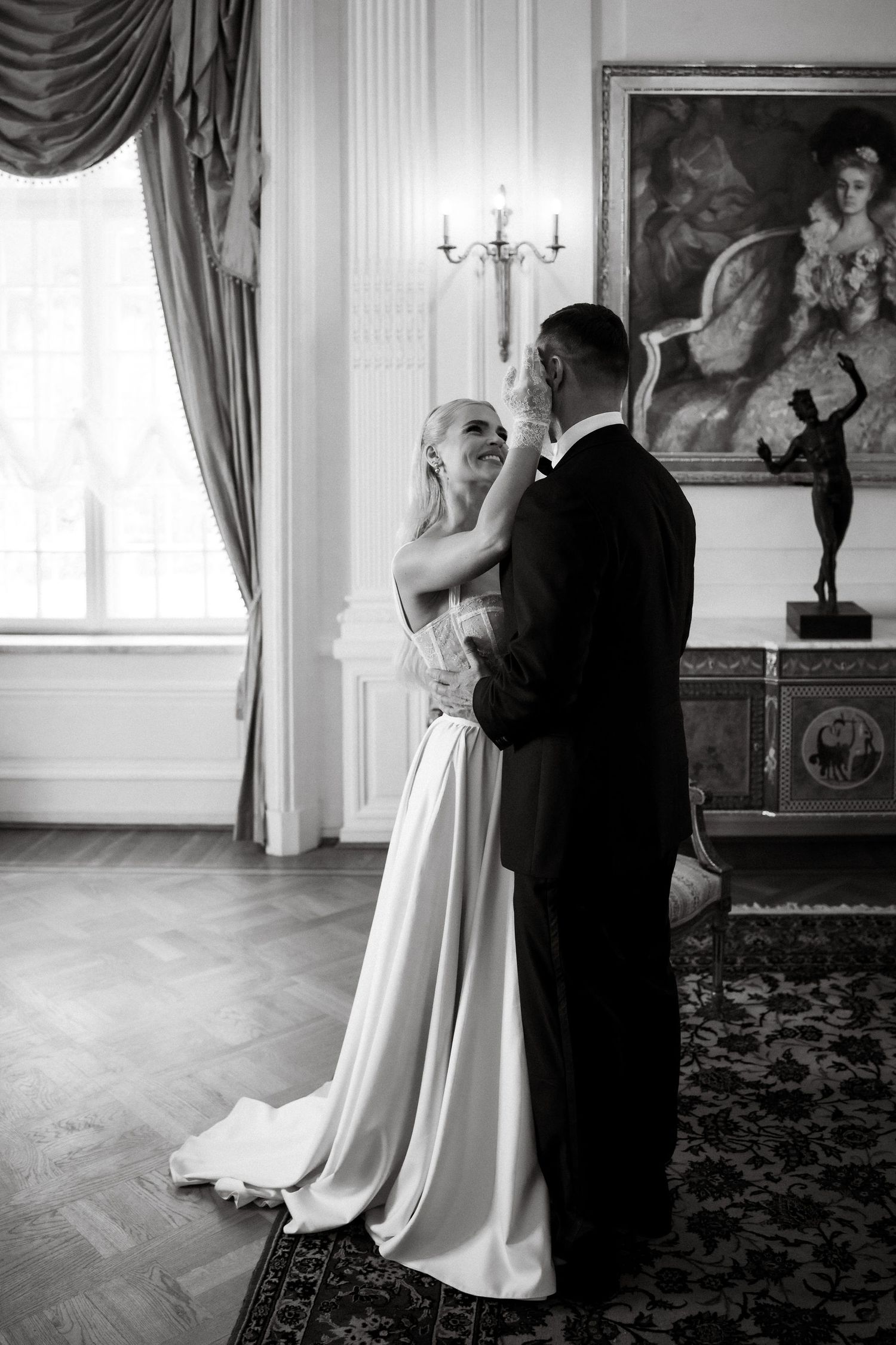Black and white photo of a couple dancing in an elegant room with vintage decor.