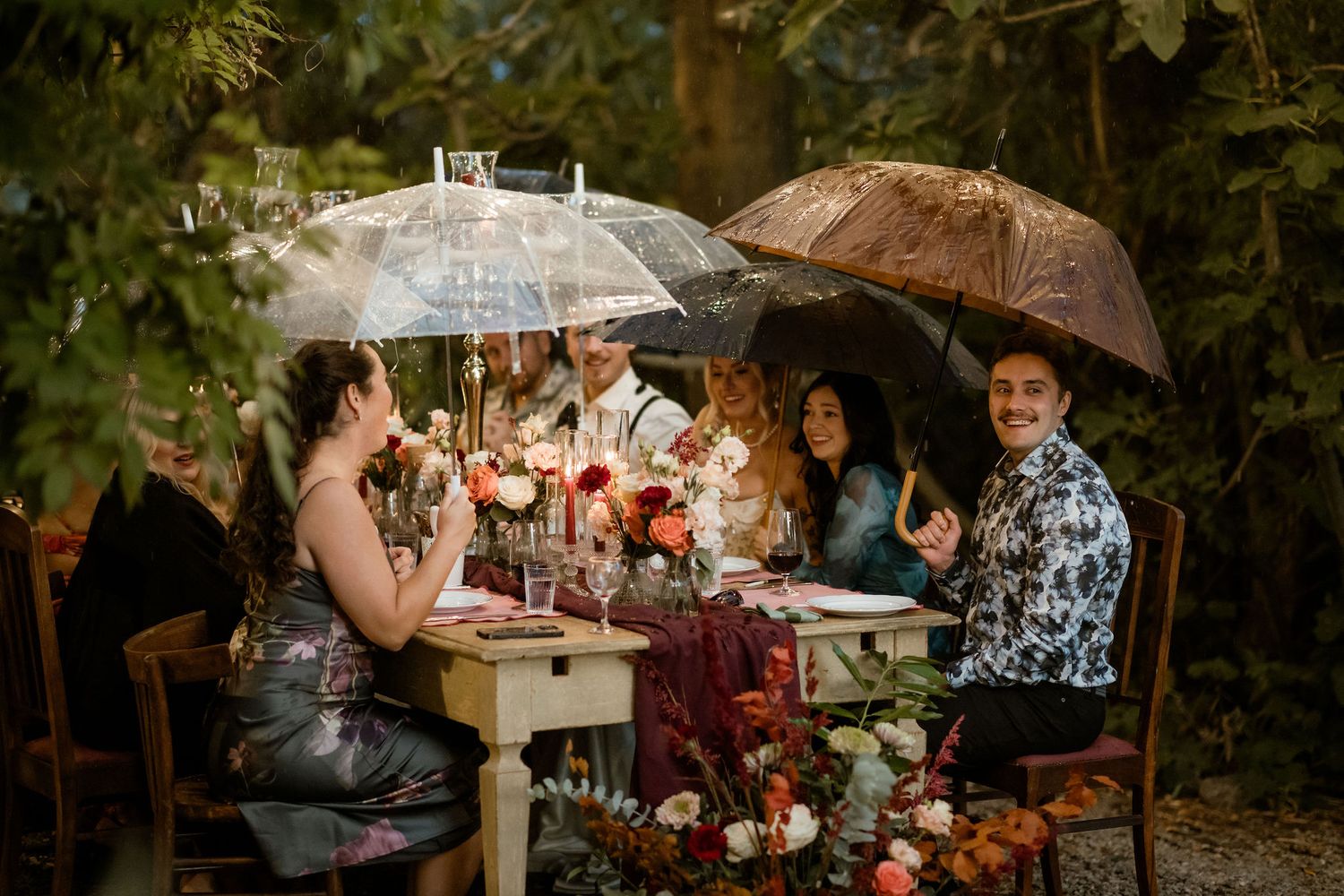 A romantic outdoor garden wedding ceremony with string lights and umbrellas creating a magical atmosphere.