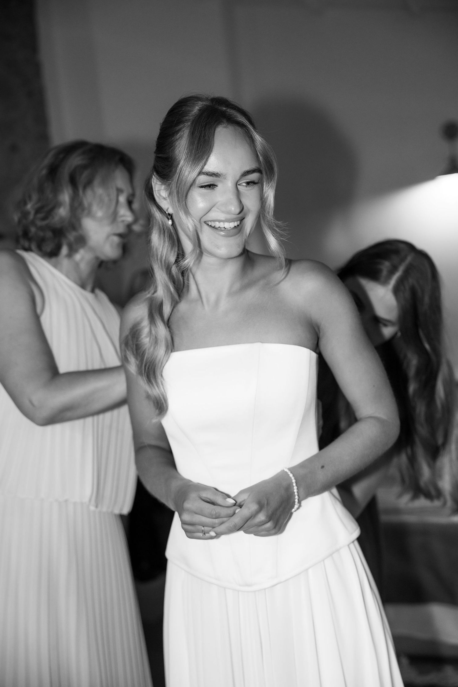 Black and white candid shots of people in white dresses sharing happy moments and embraces.