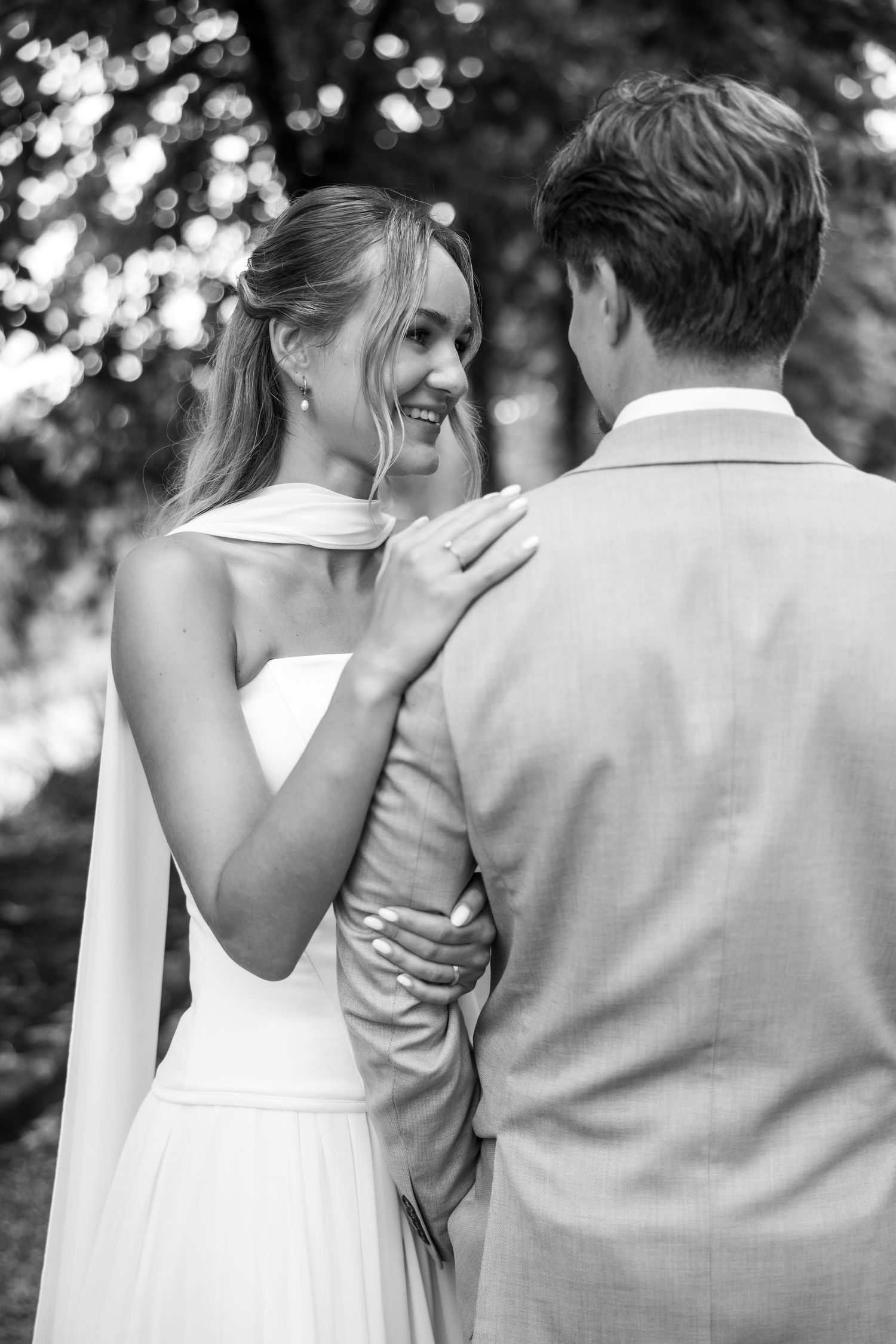 A couple embraces in an intimate black and white wedding photo sequence showing tender moments from behind.