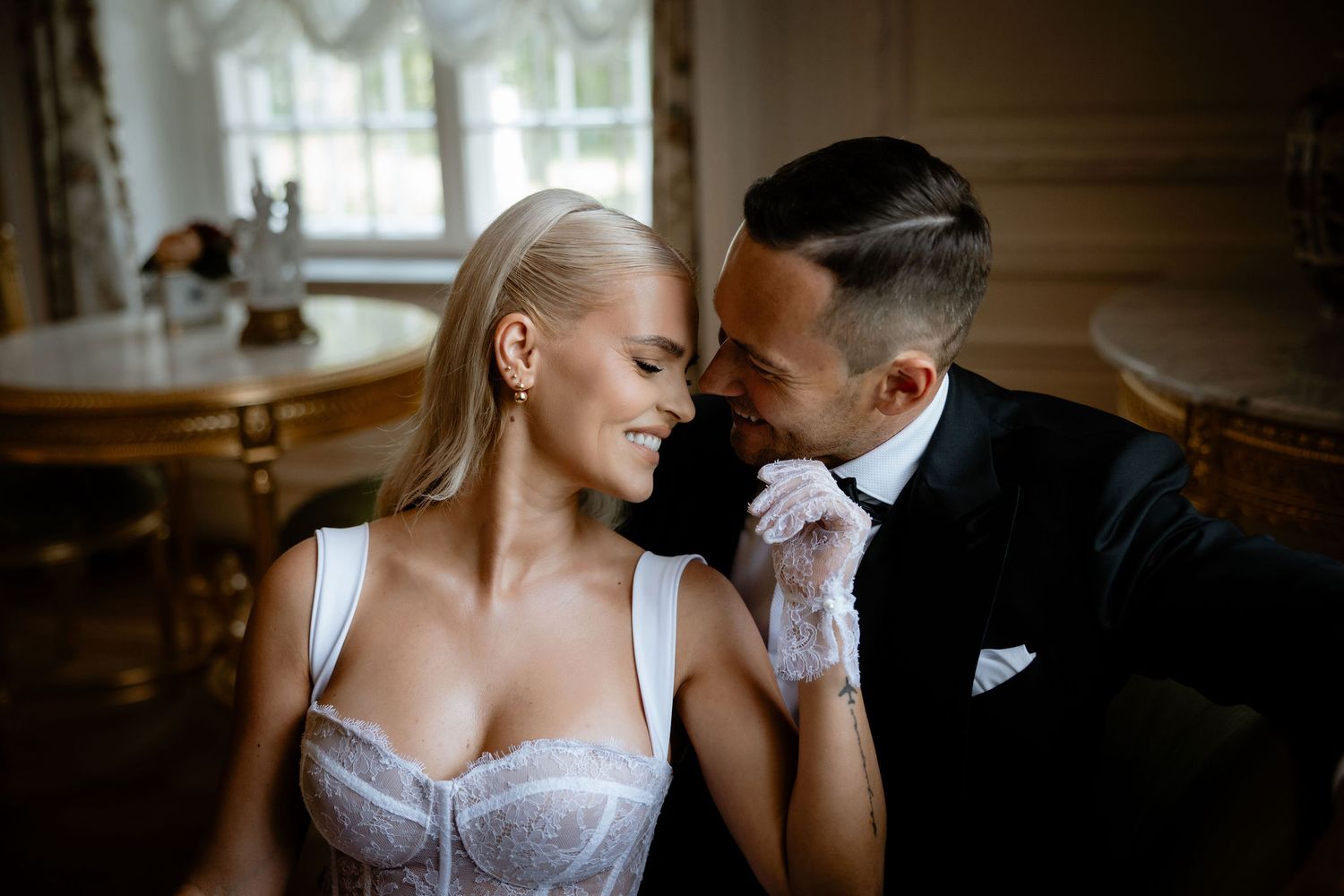An intimate wedding portrait shows a couple in formal attire sharing a tender moment.