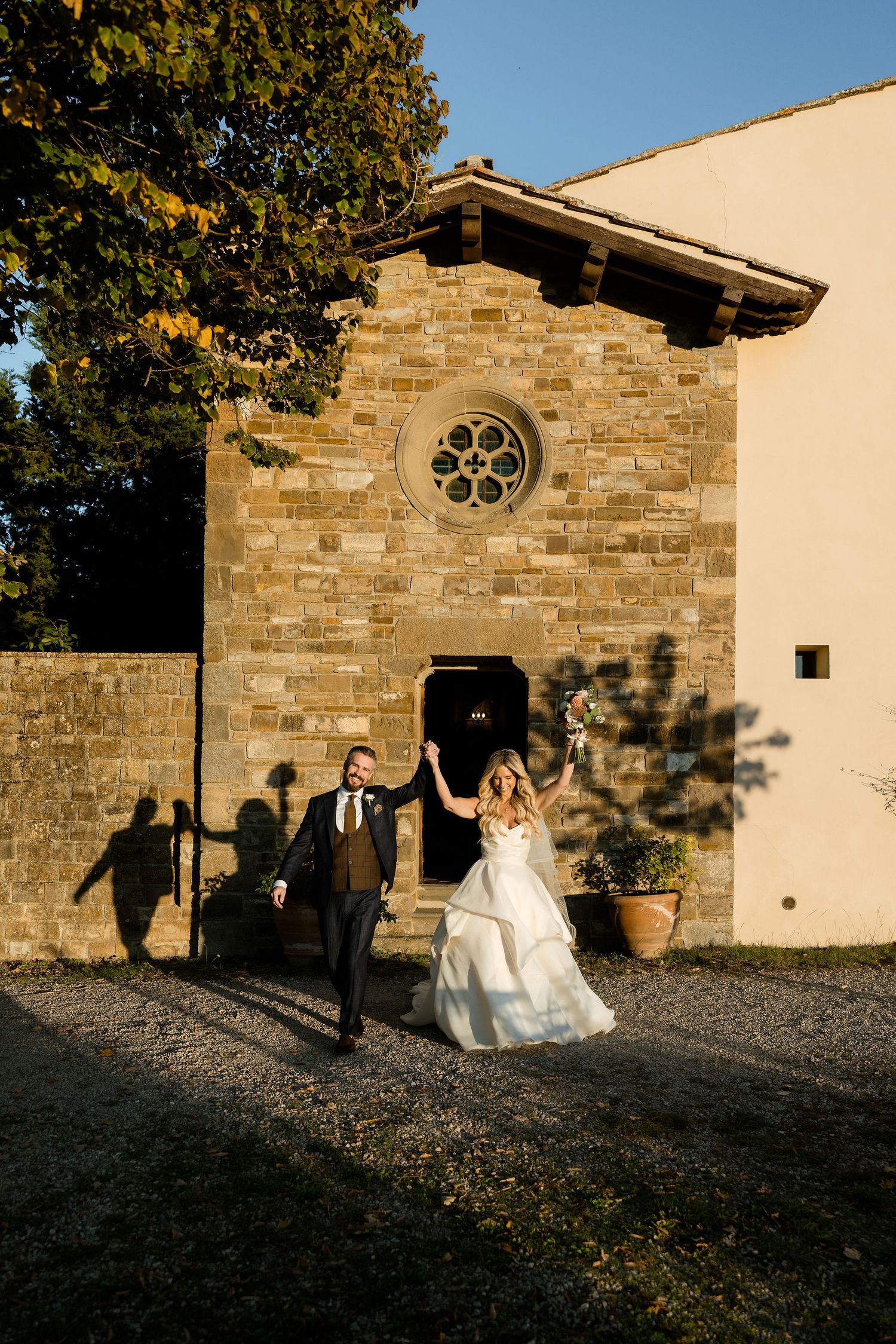 Shadows cast on stone church wall during golden hour create silhouettes against rustic architectural backdrop.