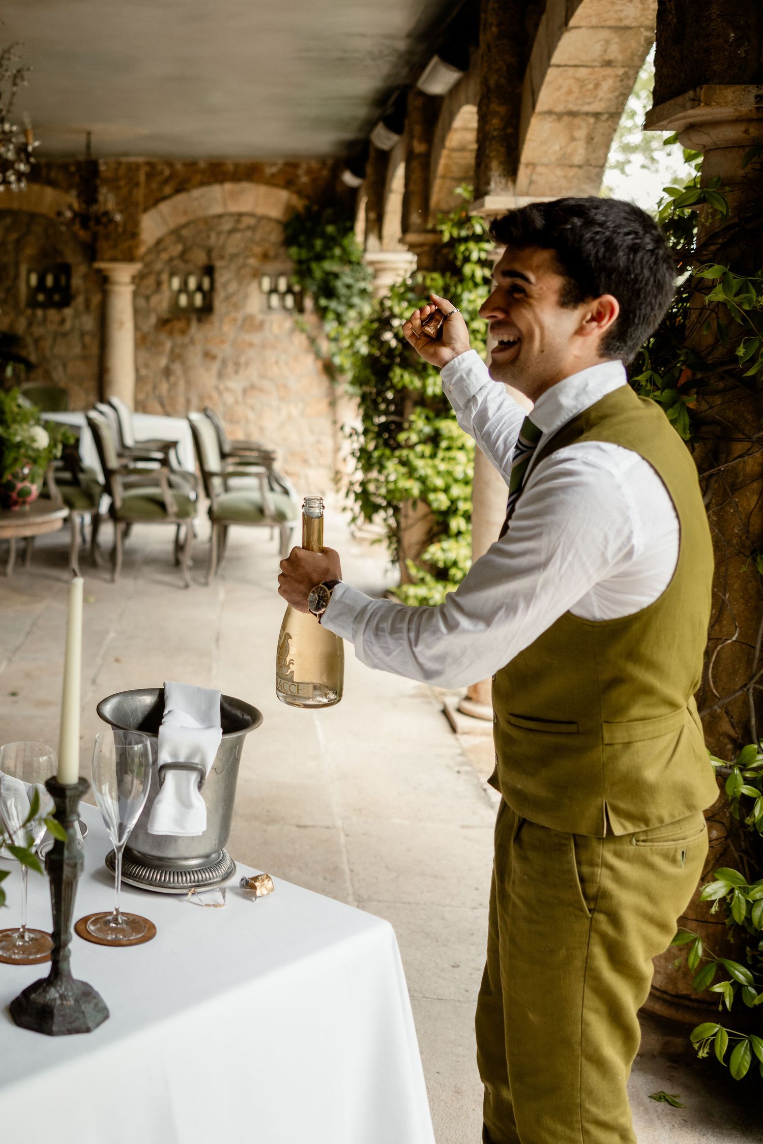 Four sequential photos show someone sampling wine or spirits in a stone-walled space with elegant white tablecloths.