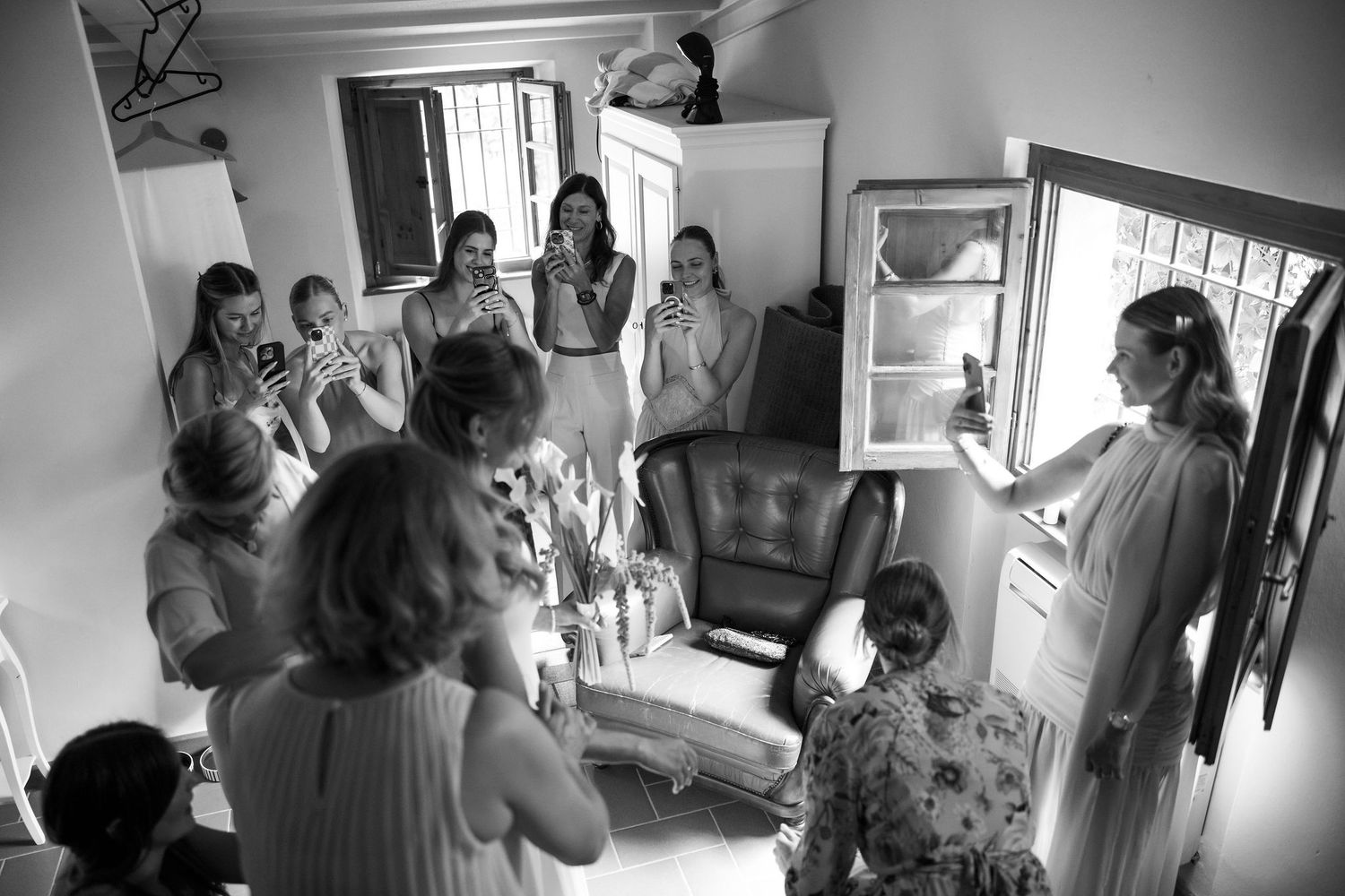 A series of black and white photographs showing people getting ready in a room with natural window lighting.
