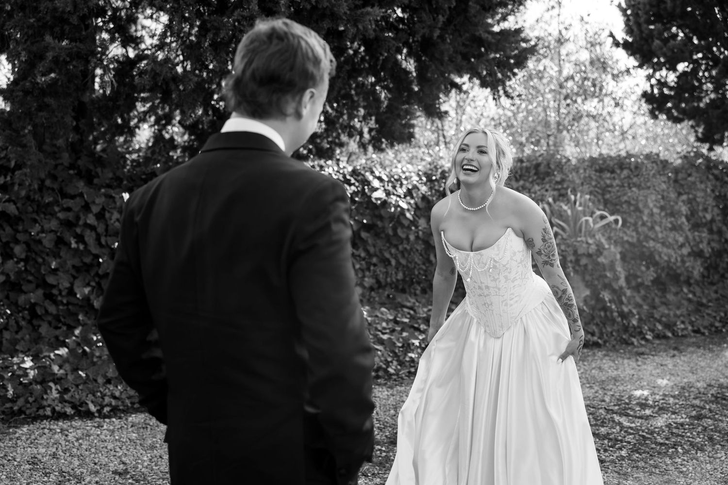 A bride and groom share intimate moments during their outdoor wedding photoshoot in a garden setting.