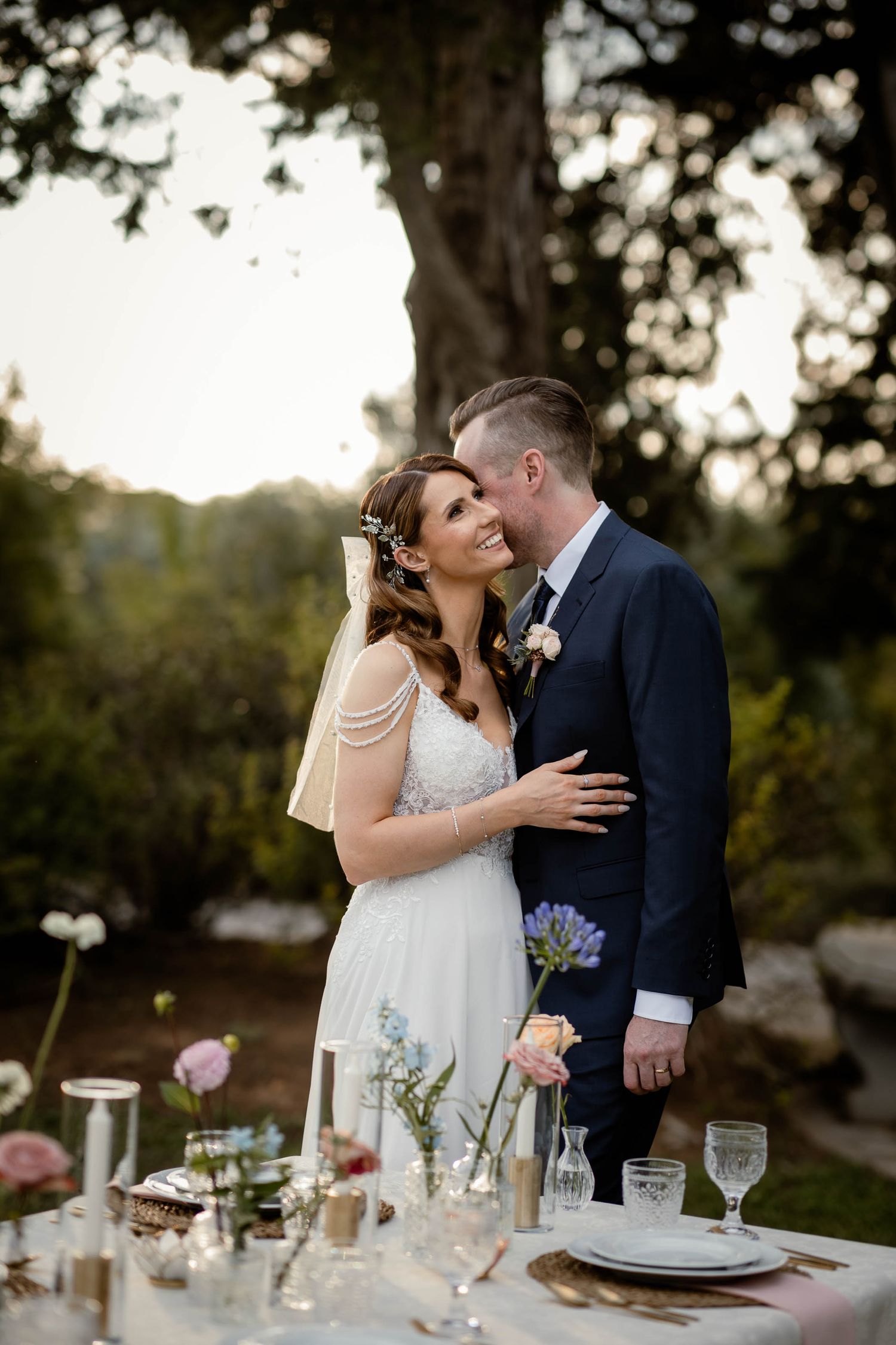 Intimate garden wedding moment with decorated dining table in foreground.