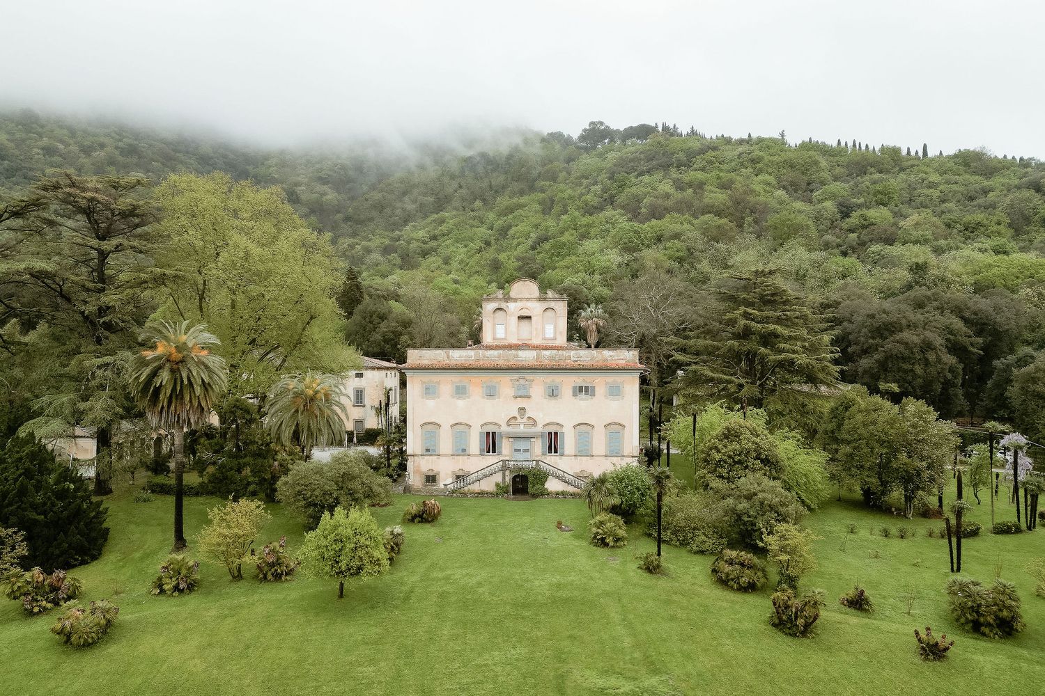 A series of misty green landscape views with historic buildings nestled among lush gardens and rolling hills.