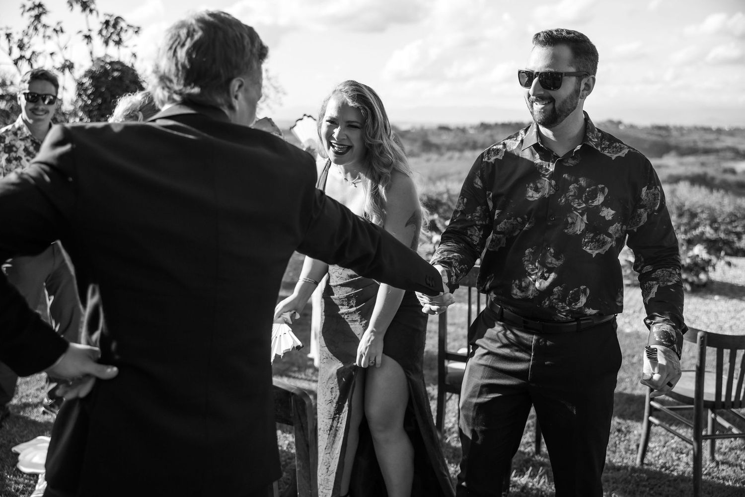 Black and white photo sequence showing people celebrating outdoors with drinks and laughter at a casual gathering.