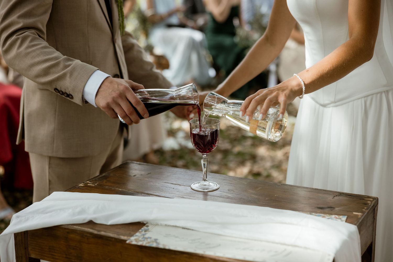 Wedding guests raise glasses in a celebratory toast during an elegant outdoor reception.