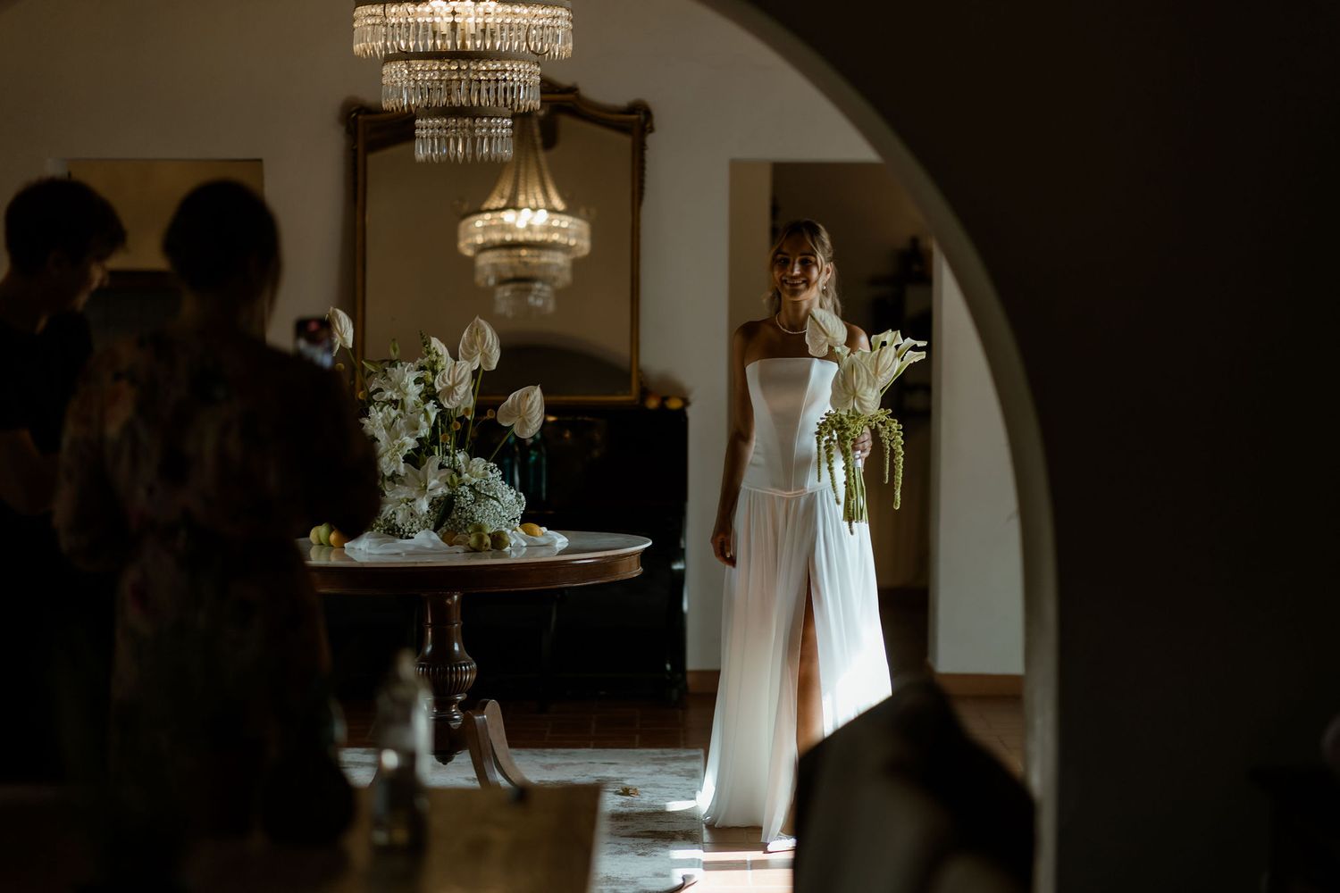 A series of dark moody wedding detail shots showing flowers, dresses, and decor in natural window light.