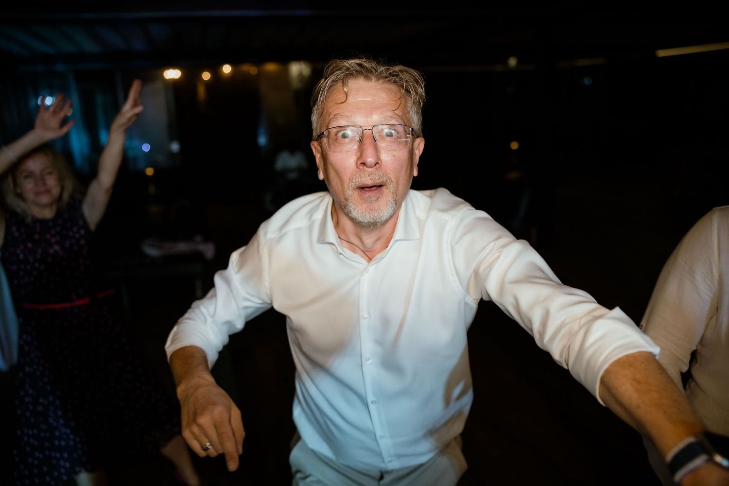 A person in a white shirt gestures while speaking during what appears to be a lively presentation or speech.