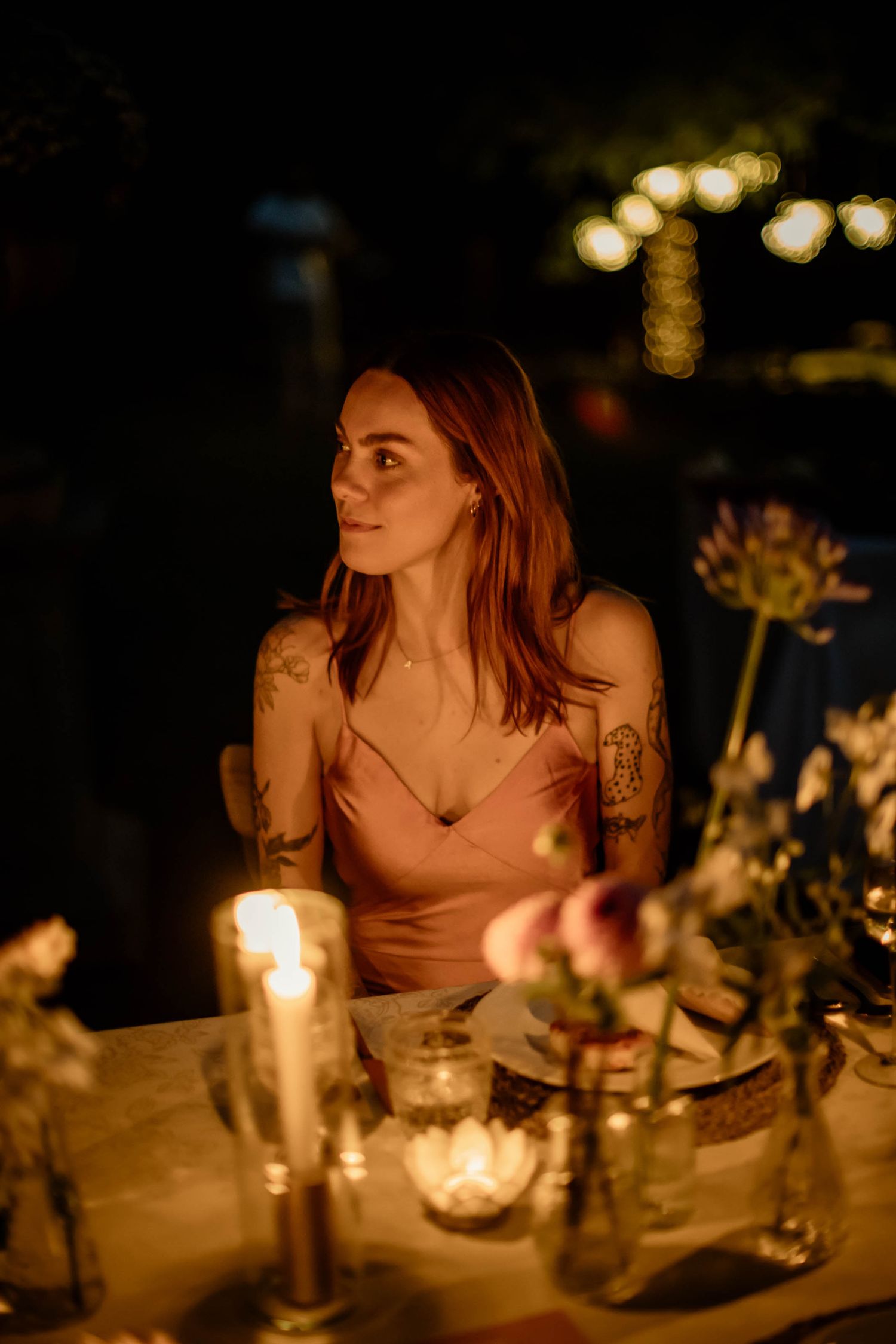A candlelit dinner scene with warm ambient lighting and floral centerpieces.