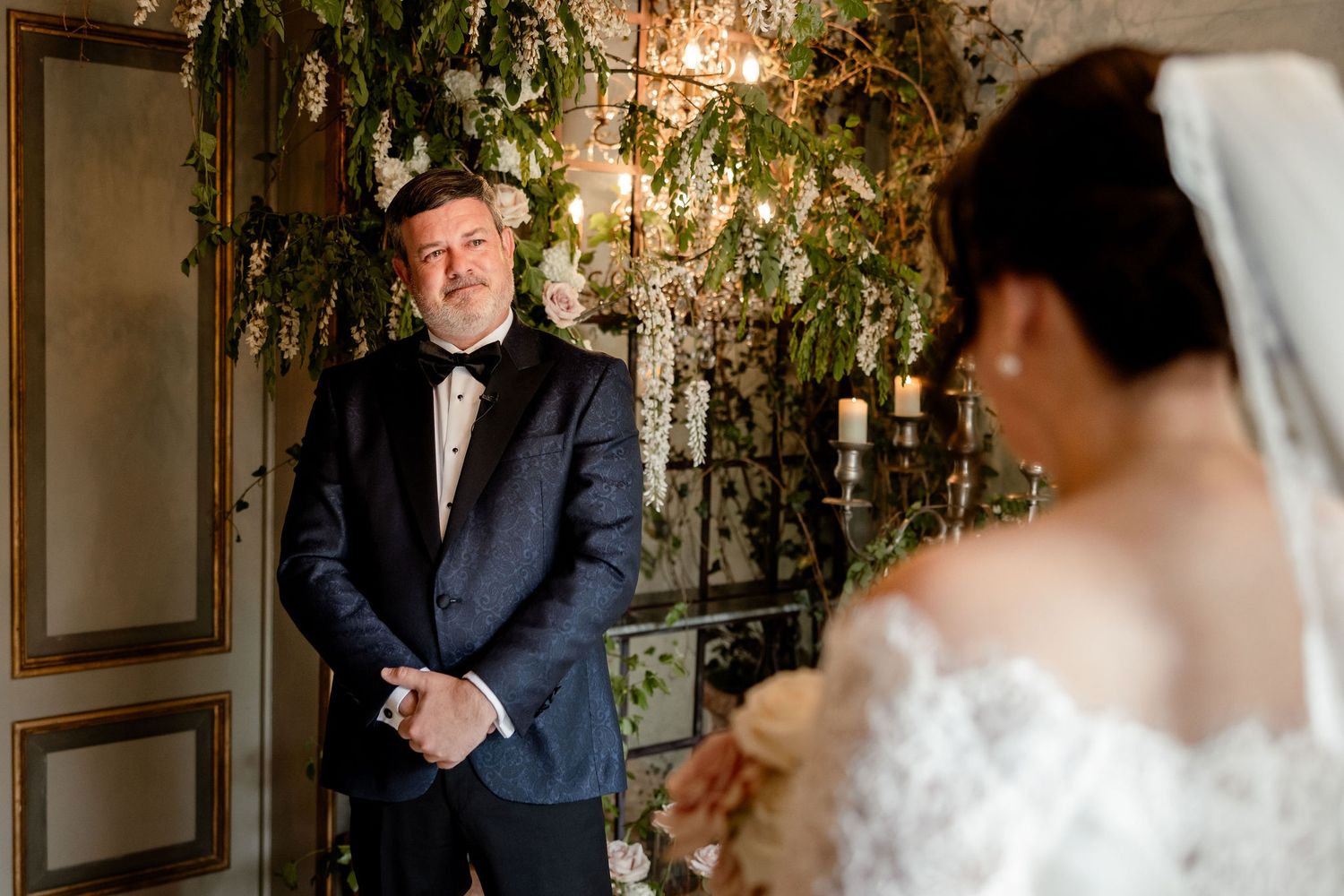 Emotional first look moment between two people during an elegant wedding ceremony in an ornate indoor setting.