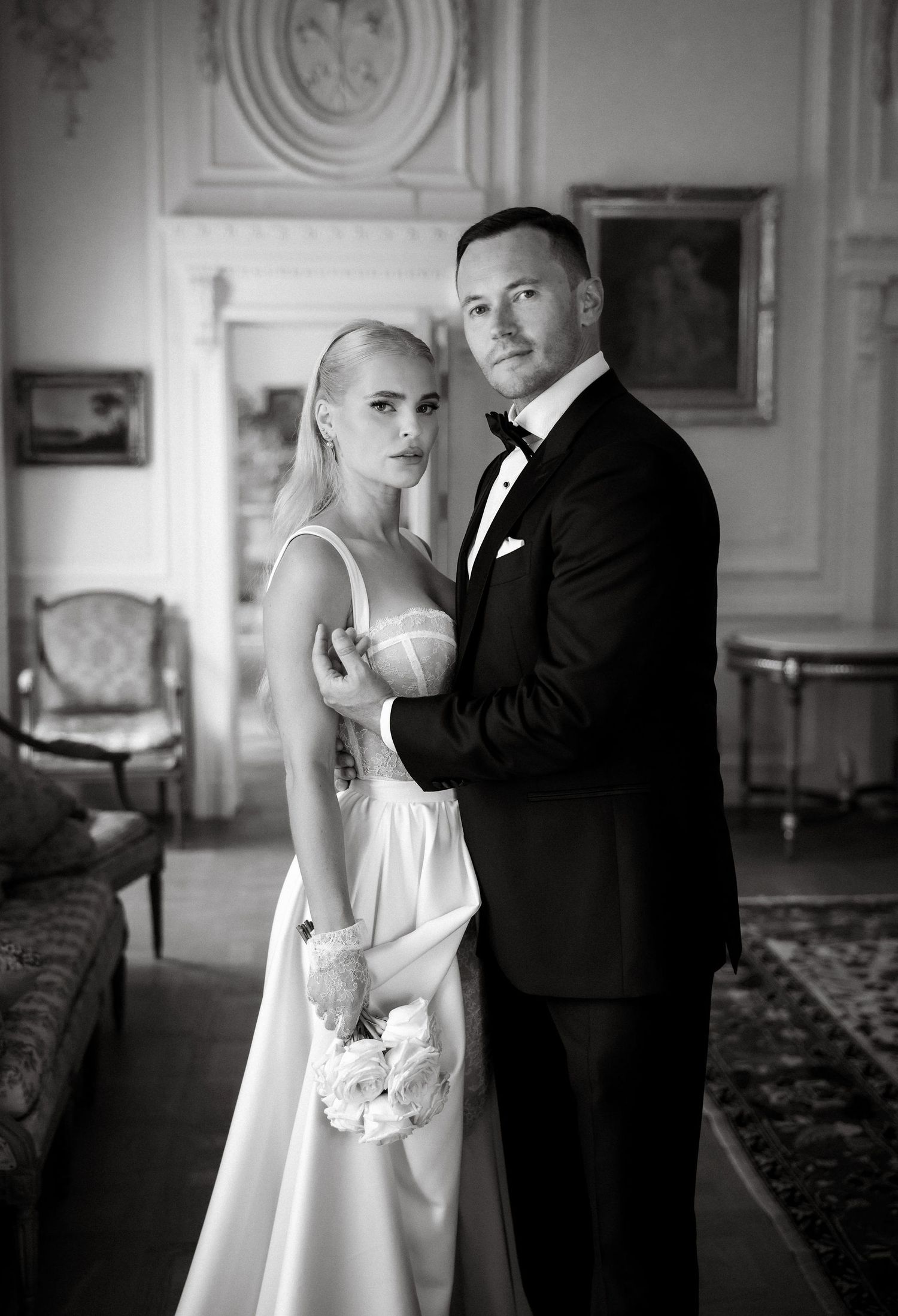 Classic black and white wedding portrait in an elegant room with vintage decor.
