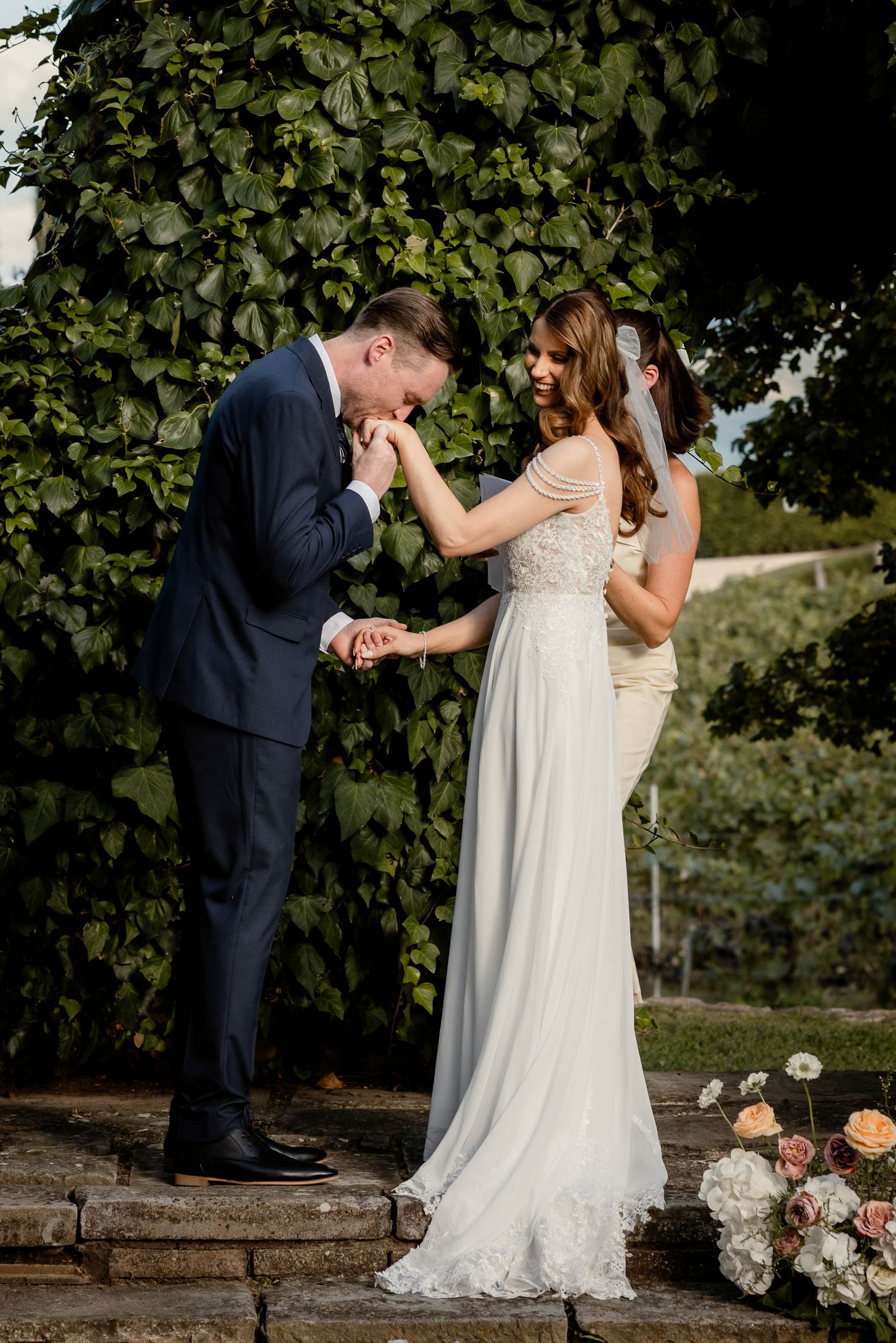 A tender moment shared during a garden wedding ceremony with floral decorations.