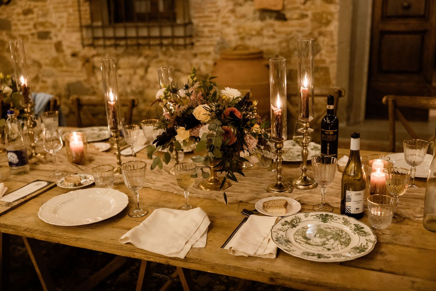 Elegant wedding reception table settings with glowing candles and floral centerpieces create a romantic atmosphere.