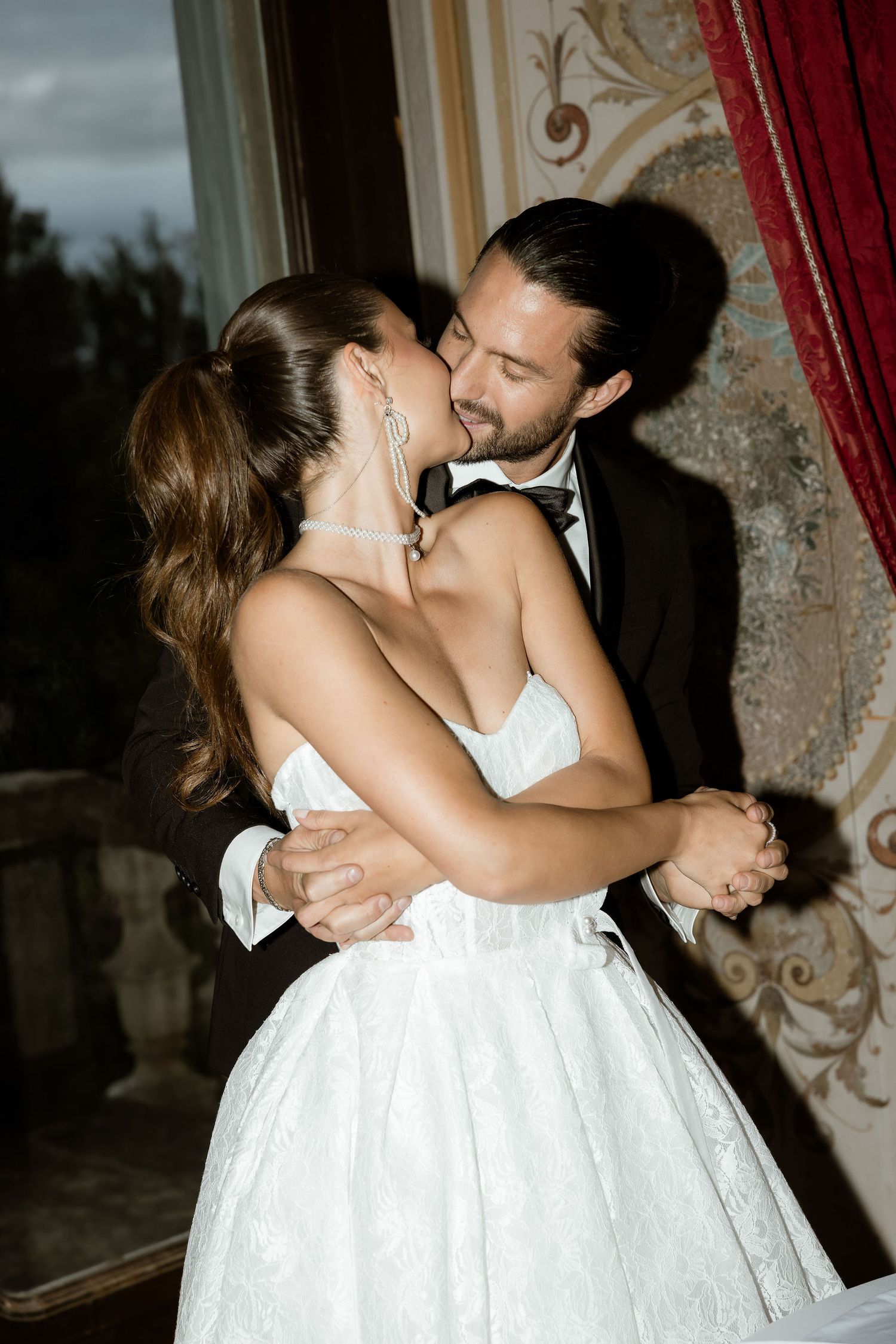 A romantic dance between a newlywed couple, with the bride in a white dress and groom in a tuxedo sharing an intimate moment.