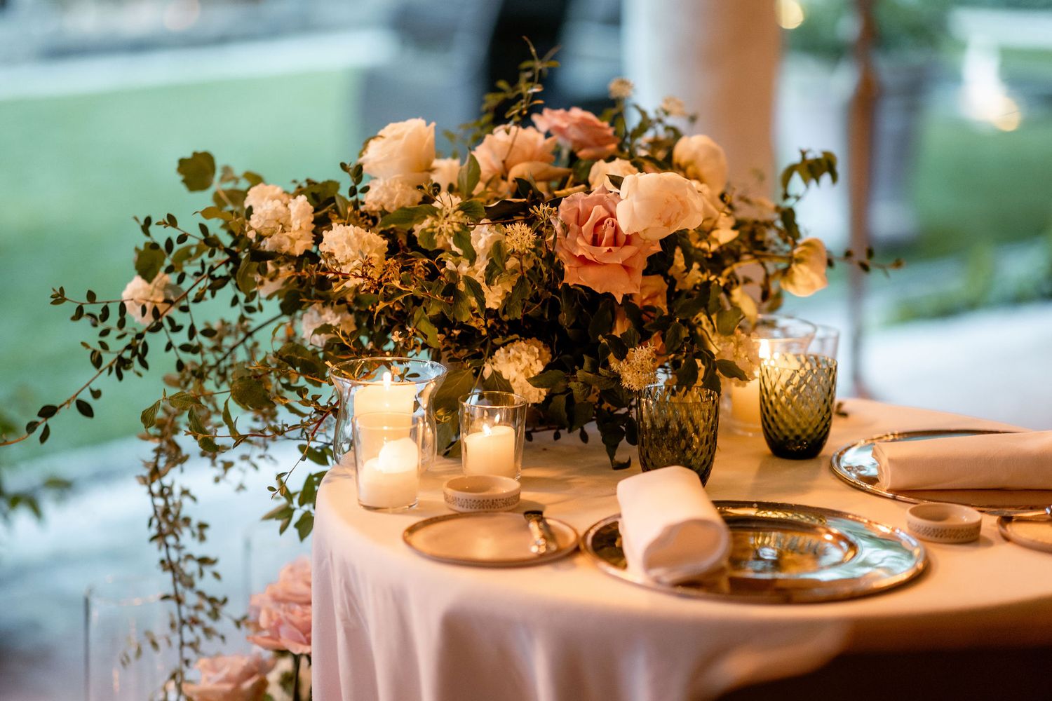 Elegant wedding reception table settings with candlelight and floral centerpieces create a romantic ambiance.